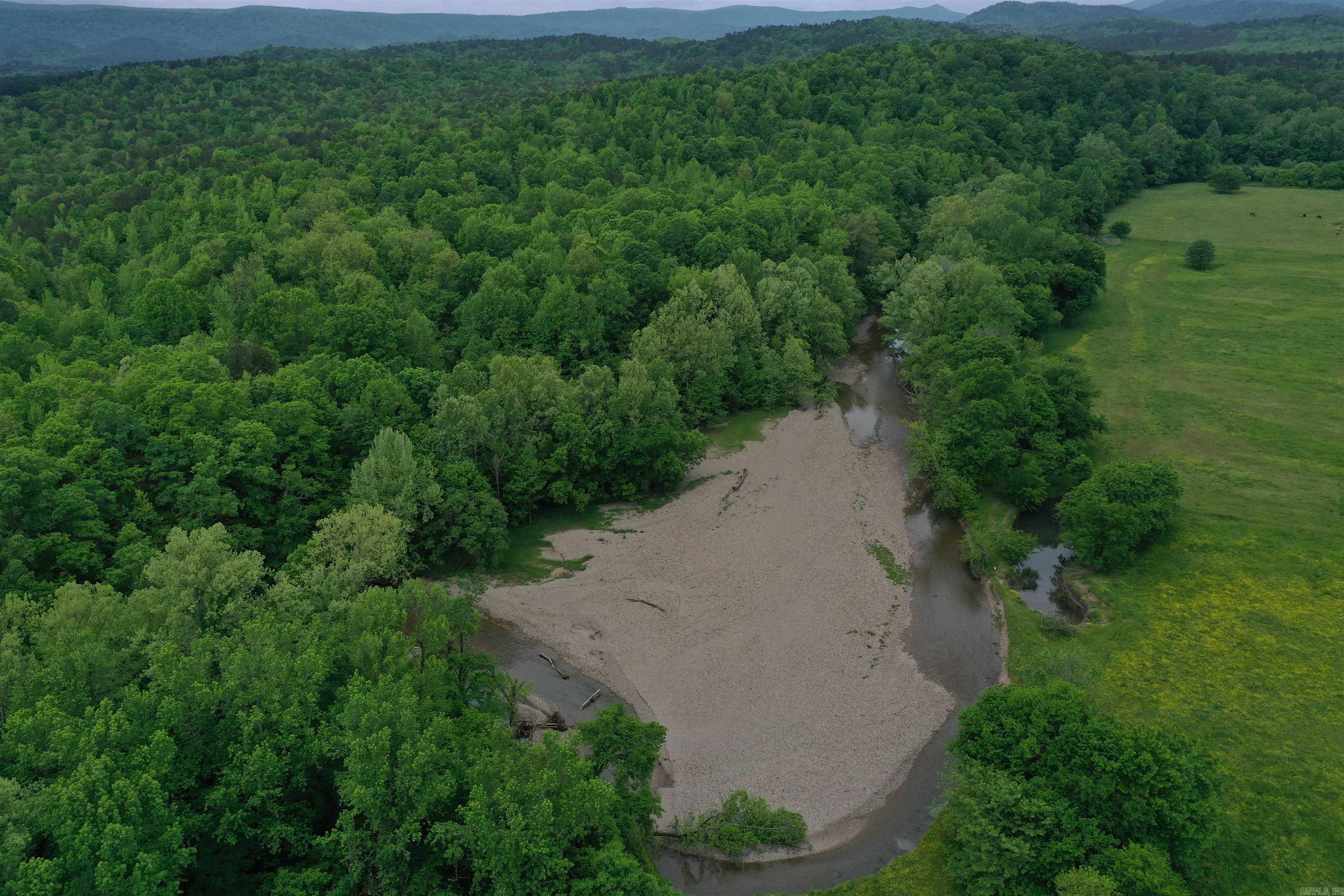 Located just outside of Norman in the community of Black Springs, this Montgomery County 174+/- acres is loaded with hard to find features and has something for everyone! The crystal-clear waters of the Caddo River are some of the most sought after in the region, and after taking a look at the beautiful river frontage on this property it will be easy to see why. As you pull through the steel gate and entry way, you’ll wind down the gravel drive up to a park like hilltop overlooking the river. Relaxing by the fire and listening to the babbling of the shoal directly below the hill is the definition of relaxation for many. From the cleared build site, it is an easy walk or side by side ride down the hill right to the edge of the water. Whether you enjoy fishing, floating, or just spending some time with your toes in the water, this is the perfect place for you. Along with the half mile of frontage along the Caddo River, the property boasts 1.2 miles of boundary with the Ouachita National Forest, giving access to hundreds of thousands of acres for hunting, fishing, hiking, and enjoying The Natural State.