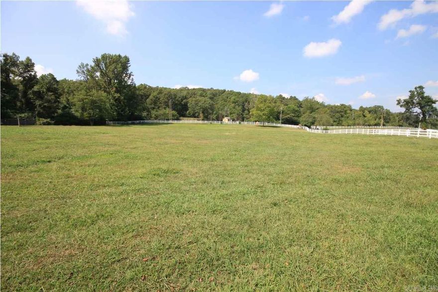 Gated and perfect for horses.  Located only minutes from Chenal Parkway.  Backs up to Chenal Downs.  Lovely home site with large oak trees.  Designer barn with heated and cooled office and open airy stalls. Lots of added storage . Wonderful horse trailer garage with drive-thru  doors. Lovely white fencing. This barn is not only safe and comfortable for your horses but convenient and functional  for their care givers. Don't miss this perfectly located property.