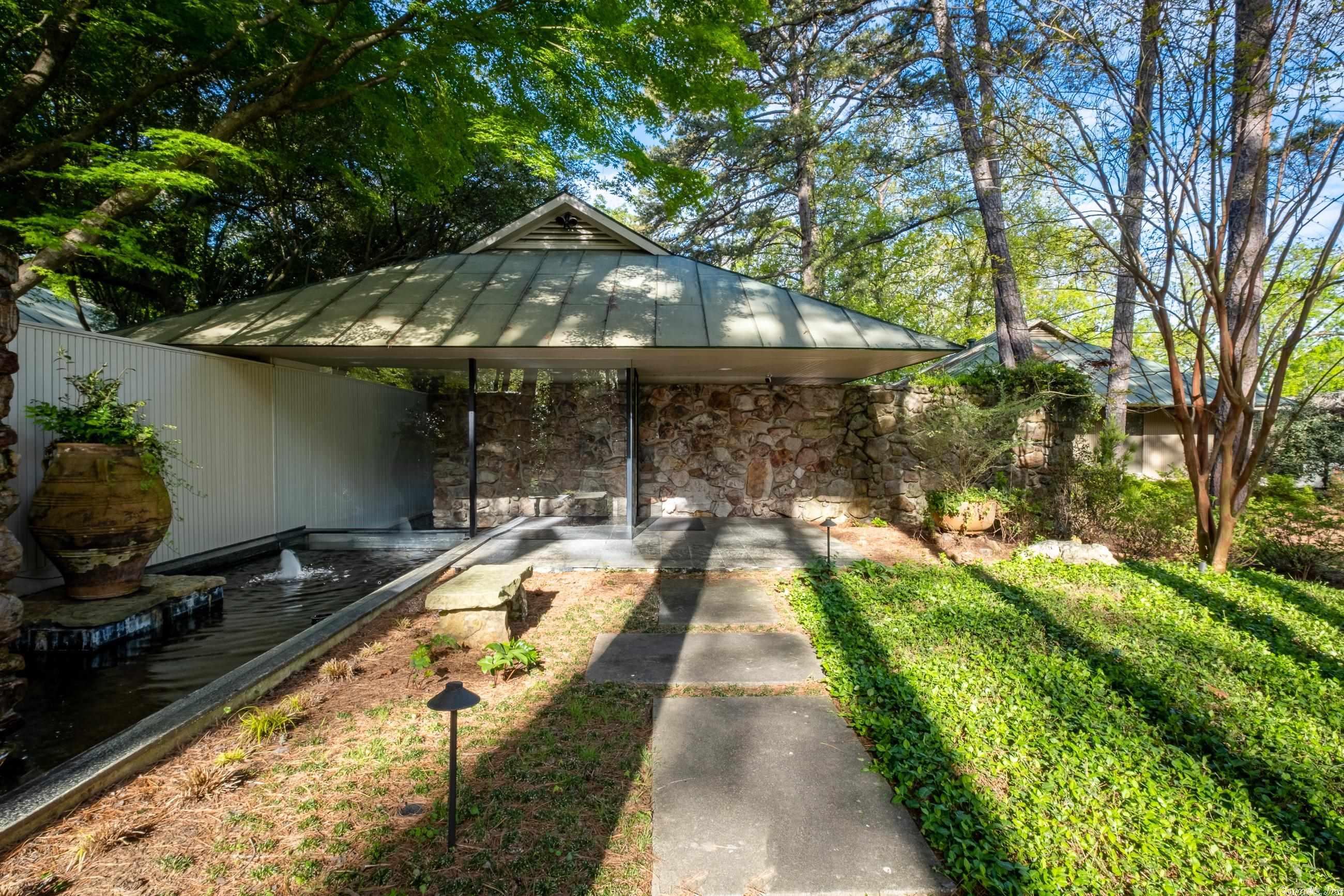 A sophisticated custom designed contemporary on a large lot offering unexpected privacy. The large floor to ceiling window blend the indoors with the outdoors. This three bedroom home has been completely remodeled with a sleek kitchen with beautiful cabinetry,handsome white bathrooms, white pine floors, extensive indoor and outdoor entertaining areas and lovely landscaping. Has a three car rear loading carport, new laundry, new HVAC, new flat roofing, exciting water features and much more. A list of improvements is in booklet on kitchen counter. It reminds you of a piece of art due to its design and composition.
