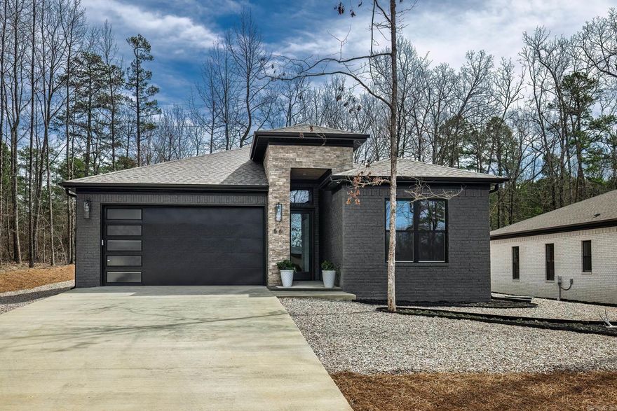 Fall in love with this beautiful home.  From the moment you walk through the 10 foot glass front door you will be impressed with the amenities of this home. Great room with gas fireplace and designer surround shelving and cabinetry for storage and beauty.  Kitchen features a large solid island, walk in pantry, lovely ceramic backsplash, more than ample counters and cabinetry, sink is located on side wall with a view of the wooded area.  Dining area boasts a stunning light fixture in a very spacious area.  Primary suite has lots of light, large bath with oversized shower and closet. Two guest rooms share bath with dual sinks, large shower tub combo. Each guest room has large windows and spacious closets.   Hot Springs Village is a 26,000-acre gated community with 11 lakes, 9 golf courses, white sand beach, hiking trails, pickle ball, fitness center, indoor and outdoor pool, tennis and SO MUCH MORE.  One time POA buy-in fee $2000 due at closing.  Taxes are on vacant land