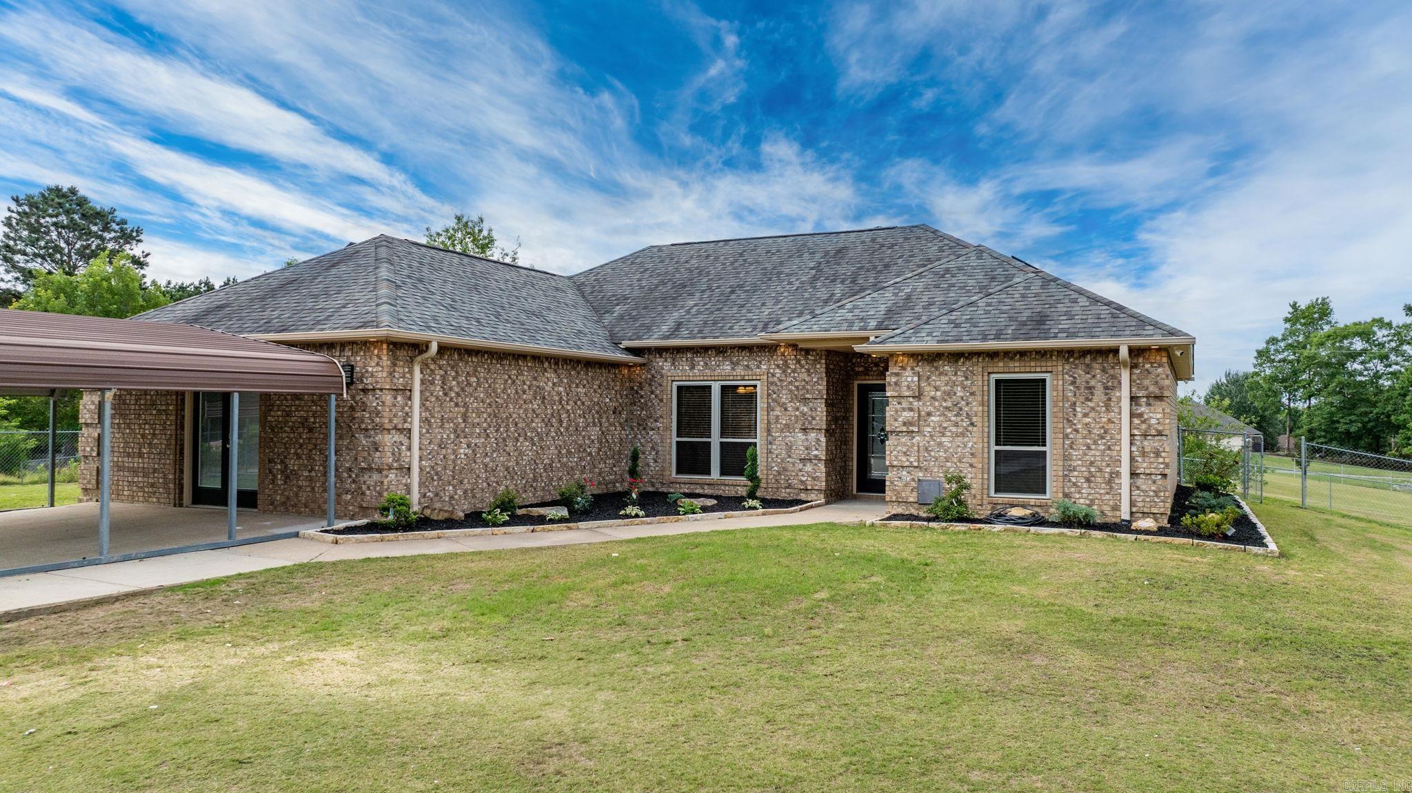 Modern Country Living on 2.23 Acres – Solar Powered & Private - 11 miles from I-30/Benton! Enjoy the best of both worlds in this stunning Bauxite home—nestled on 2.23 fully fenced acres with a gated driveway for ultimate privacy. This all-electric home features a complete solar system, keeping monthly electric bills around $14! Inside, you’ll find luxury vinyl plank flooring, an open-concept layout, a wood-burning fireplace, and a bright kitchen with granite countertops and tons of natural light. Designed with comfort and functionality in mind, this home features a split-bedroom layout with dual primary suites sharing a spa-like bath with a soaking tub, walk-in shower, double vanities, and large walk-in closet. Two additional bedrooms and a full guest bath are thoughtfully located on the opposite side of the home for added privacy. Extras include an oversized 2-car garage/shop, 4-car carport, storage buildings, and a heated/cooled sunroom perfect for relaxing year-round. Located just minutes from Bryant and Central Arkansas conveniences—don’t miss this private, energy-efficient gem!
