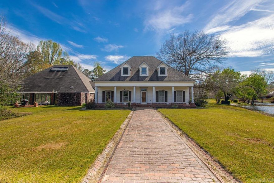 Experience the ultimate in lakeside luxury with this unique property, where the rare perk of an indoor swimming pool meets the serenity of cul-de-sac living. This home welcomes you through a bright sunroom transition that leads into an elegant living area anchored by a charming wood accent wall. The thoughtful floor plan features a primary suite on the main level overlooking the water, while the upstairs offers two bedrooms joined by a versatile game room and a full bath. Outside, a beautiful front porch provides the perfect vantage point for morning coffee with a lake view, and the oversized two-car garage includes a climate-controlled bonus room with a half bath—ideal for a mini-apartment or guest suite. With numerous updates throughout and endless opportunities for fishing and kayaking right from your own backyard, this home offers an incredible lifestyle at an unbeatable price. Bonus room above garage (483 sqft) is not included in heated/cooled space within the home. Indoor pool area is 2623 sq ft.