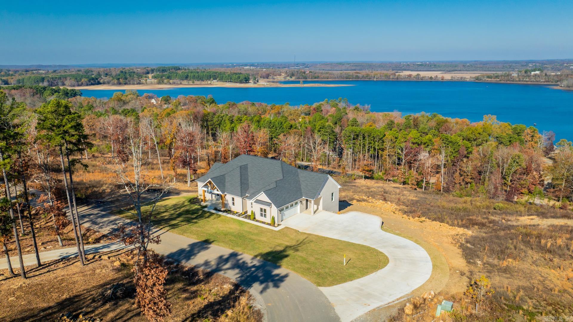 Welcome to this beautifully designed custom-built home, offering the perfect blend of comfort, luxury, and natural beauty. Situated with breathtaking views of Beaver Fork Lake.   This 4-bedroom, 3-bathroom home features an open-concept layout, a spacious kitchen, and a cozy living area, all designed with high-end finishes. The expansive master suite provides a serene sanctuary with lake views, while the additional bedrooms are perfect for family or guests.  Enjoy extra living space with a versatile bonus area in the finished basement, offering endless possibilities as a home theater, gym, or recreation room.  Step outside to your private oasis where you can relax on the patio or deck, soaking in the tranquil surroundings and stunning lake views.  This property is perfect for those who appreciate nature, luxury, and the convenience. Don’t miss the chance to make this incredible home your own!