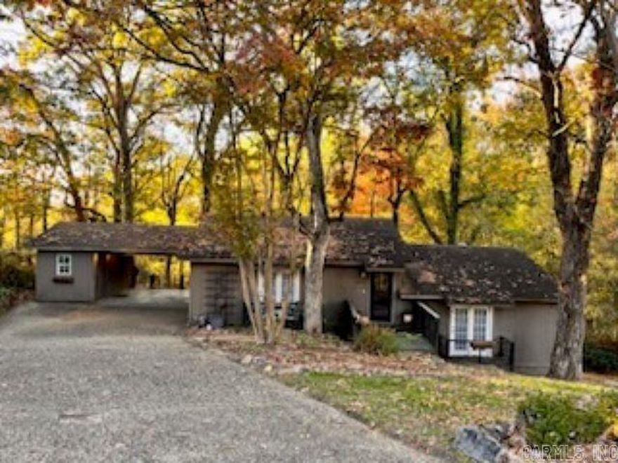 Unique home in North Little Rock sitting on a large lot that backs up to woods and walking trail.  The home has bamboo flooring and water proof vinyl title with recently new interior paint.  The kitchen offers granite countertops and subway title backsplash. Refrigerator conveys and dishwasher is 6 months old and only used a few times. Tankless water heater. Lots of natural light, tall ceilings and big windows. Small loft off the kitchen over looking the living room area, great small office space. Large deck off living room area looking over the back yard and woods behind.   Nice storage room off the 2 carport area.  Seller offering a 13 month Home Warranty.