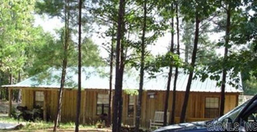 Straight out of the Ozarks, this very rustic gem of a home sets on 9.67 acres of wooded land. 1750 square feet with 2 bedrooms and 2 baths in the home and above the shop is 1 bedroom 1 bathroom. Concreate floors with an open floor plan, metal on the walls and ceilings, 2-sided fire place that makes a remarkable center piece for this home that represents beauty and a way of life by heat. Large master bedroom with 2 ceiling fans and tray lights with tin ceiling and walls give this home a very laid-back feel. The floors throughout are concreate so they are very easy to clean. One of the bathrooms has a beautiful claw foot tub, and the other bathroom has a stand-up shower with rough wood accents. The master bedroom has a walk-in closet, located in the second bedroom is an armoire closet that does not convey with sell. This home is very insulated and will be great for the summer and winter! The last owner-built cars and added a car lift, commercial air compressor, and balcony storage area in the outside garage. The garage also has concrete floors, bathroom, and office area. The back work shop would be great for a crafts man, (last owner had a mandolin workshop) man cave, or car enthusia