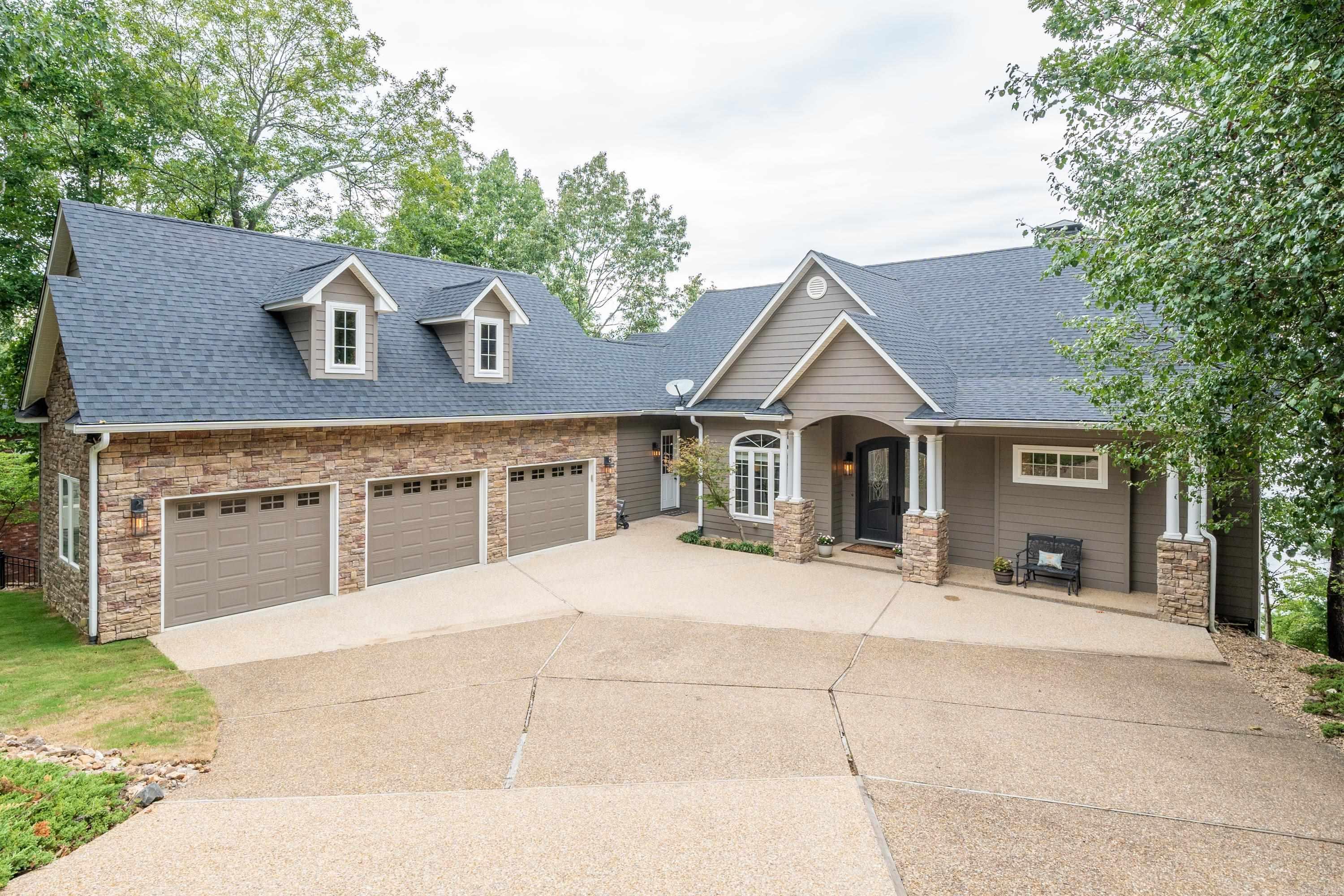 THE BEST OF LAKE LIVING with AMAZING VIEWS! Enjoy all that Lake Hamilton has to offer in this UPDATED 4 bedroom, 3.5 bath 4,098 square foot home right on the water's edge in the coveted Stonegate Subdivision. INCREDIBLE VIEWS from almost every room. Beautiful waterfall in back yard, screened in porch overlooking the lake, new 2 stall covered boat dock with lift and swim platform 2023, double sea doo dock, year round water, new roof and gutters August, 2023, 3 car oversized garage with tons of storage in partially finished room above garage that could be converted to heated/cooled square footage for added room. Main level features primary suite with spa like ensuite bathroom, living room, office, kitchen, 1/2 bath and laundry room. Downstairs features 3 bedrooms (including another primary suite with ensuite bathroom), 2 bathrooms, living room area and bonus room/game room. This home has TONS OF STORAGE with 3 outside accessed areas and partially finished room over garage. New HVAC, new exterior and interior paint, new tile in bathrooms, new decks with iron railing and so much more. Chef's kitchen with open design has stainless appliances, double ovens and island with gas stovetop.
