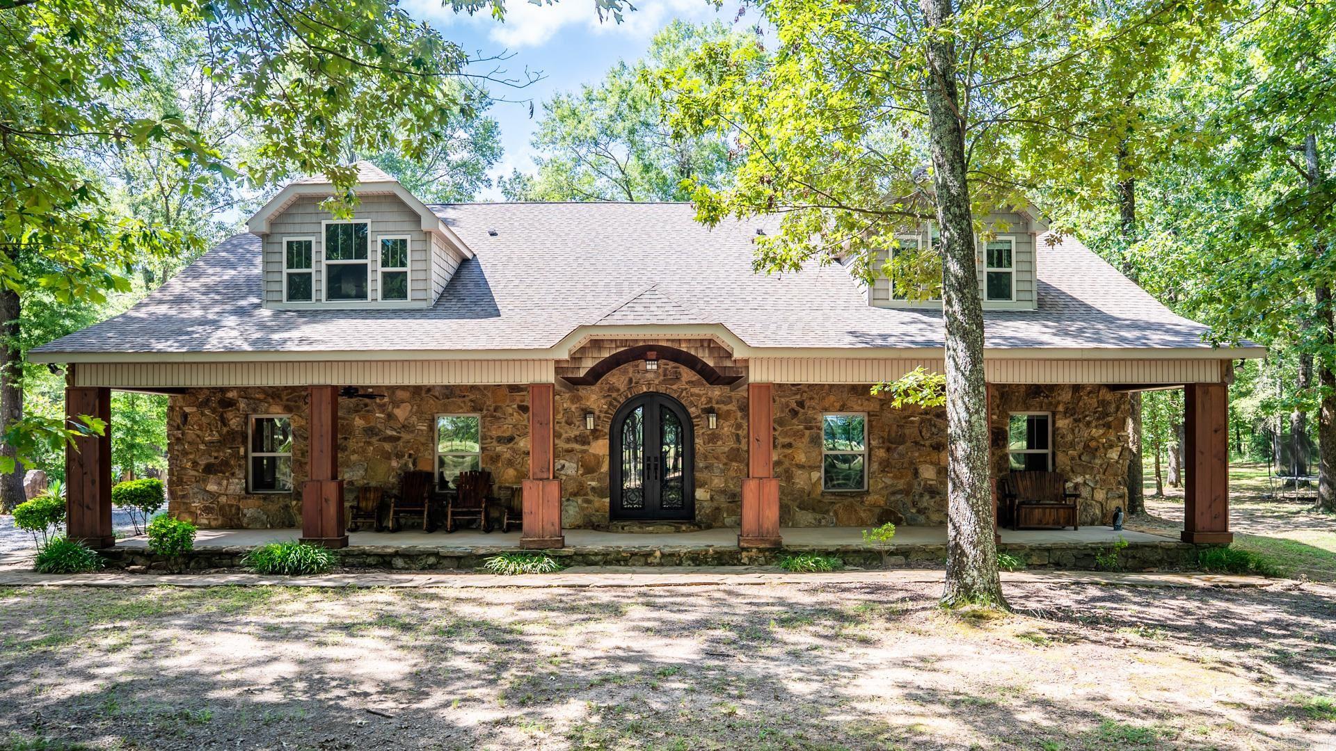 Tucked behind a gated entrance on 5.3 serene acres, this elegant 5,035 sq ft Craftsman/ Ranch Style home offers luxury, privacy, exceptional versatility and a GUEST HOUSE. From the custom iron double doors to exposed beams and epoxy-stained floors, every detail reflects thoughtful design and timeless style. Inside, you'll find an open-concept kitchen with oversized island with a granite counter-top, a stunning great room, and a first-floor primary suite that provides spa-inspired comfort. A dedicated office ensures you can work from home in peace, while a spacious bonus room with dry bar adds flexibility for entertaining, media, or multigenerational living. Multiple storage areas throughout the home ensure everything has its place. Outdoors, enjoy a 1,400 sq ft partially covered patio with a stone fireplace and built-in grillāperfect for year-round entertaining. A separately metered 750 sq ft guest house with full kitchen and bath offers upscale accommodations for extended guests or private use. Luxury meets lifestyle in this private retreatājust minutes from city conveniences in Conway and Little Rock.