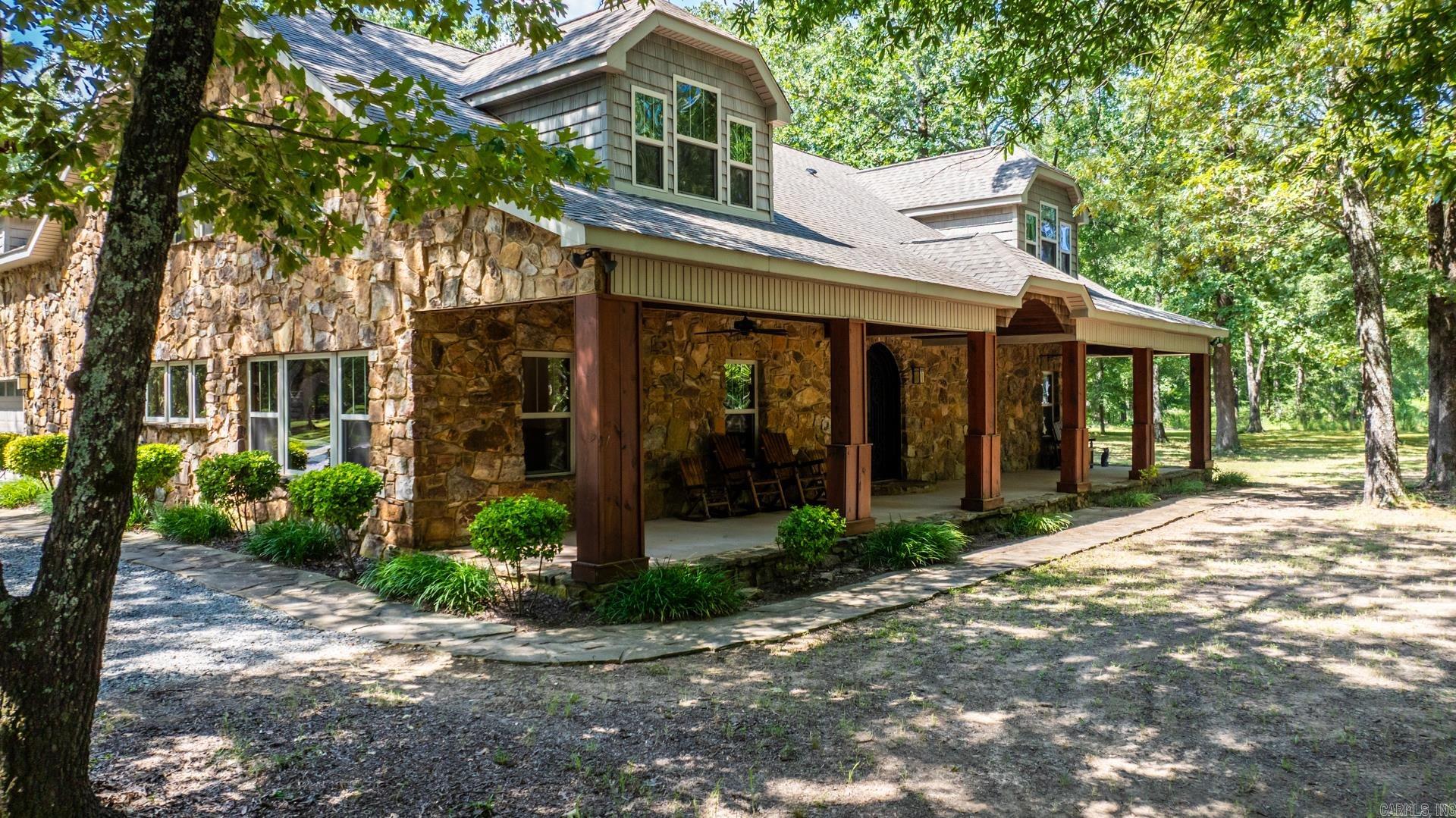 Tucked behind a gated entrance on 5.3 serene acres, this elegant 5,035 sq ft Craftsman/ Ranch Style home offers luxury, privacy, exceptional versatility and a GUEST HOUSE. From the custom iron double doors to exposed beams and epoxy-stained floors, every detail reflects thoughtful design and timeless style. Inside, you'll find an open-concept kitchen with oversized island with a granite counter-top, a stunning great room, and a first-floor primary suite that provides spa-inspired comfort. A dedicated office ensures you can work from home in peace, while a spacious bonus room with dry bar adds flexibility for entertaining, media, or multigenerational living. Multiple storage areas throughout the home ensure everything has its place. Outdoors, enjoy a 1,400 sq ft partially covered patio with a stone fireplace and built-in grillāperfect for year-round entertaining. A separately metered 750 sq ft guest house with full kitchen and bath offers upscale accommodations for extended guests or private use. Luxury meets lifestyle in this private retreatājust minutes from city conveniences in Conway and Little Rock.