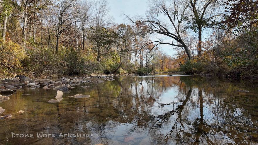 With nearly half a mile of Little Red River frontage and just under 80 acres, this property feels like a private nature preserve designed for living off the land. Towering hardwoods, maintained through annual controlled burns, create open, park-like woods with clear sightlines and easy walking throughout.  The land offers everything a homesteader or preparedness-minded buyer could want—solar power, water well, mature timber, live water, fenced pastures, cattle infrastructure, and established garden space. Rock bluffs overlook wet-weather creeks, and a natural swimming hole and fishing access sit along the river’s edge.  Wildlife is abundant, with deer, turkey, bear, and other native species moving through the property regularly. Several ideal building locations provide opportunities for additional cabins, guest homes, or future expansion.  The spacious 2-bedroom, 1-bath, 1,736 sq ft home is rustic with cypress accents, efficient, and comfortable, featuring a basement utility room for storage and solar equipment. The long, winding driveway from the front gate feels straight out of a storybook, leading you into a setting so peaceful it’s hard to imagine ever leaving.