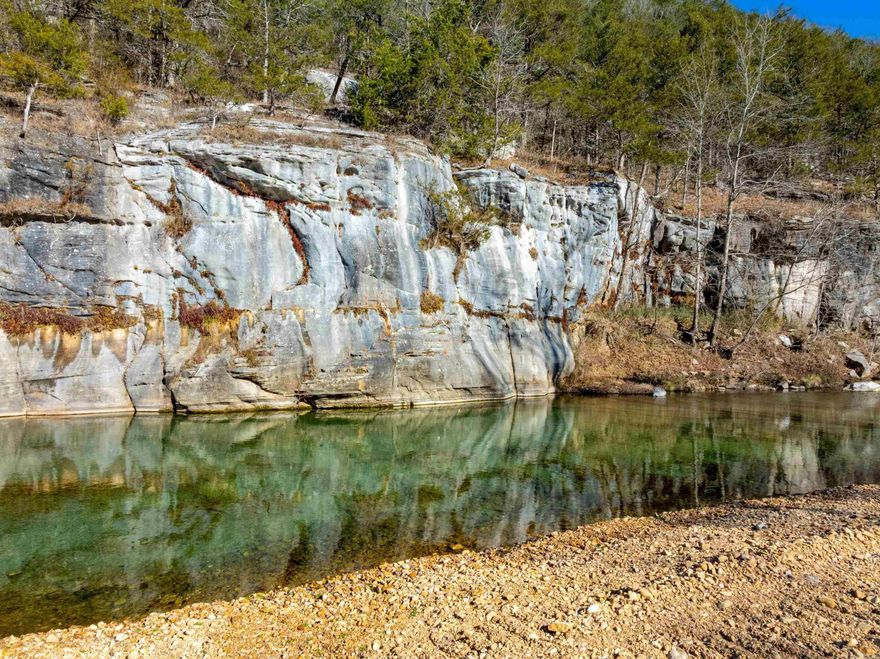 This extraordinary 191 +/- acre tract in Stone County, Arkansas is a true one-of-a-kind piece of the Arkansas Ozarks. Located approximately 2,500 feet from the White River, the property features a stunning rocky bayou, a breathtaking bluff, and a natural swimming hole that create an unmatched setting and unforgettable views. The land is predominantly wooded, offering privacy and incredible natural beauty, with select cleared areas ideal for pasture land, food plots or future building sites. Well-maintained roads run throughout the property, allowing easy access by vehicle or ATV. Wildlife is abundant, making this an outstanding hunting and recreational property, with white-tailed deer, large tom turkey, and black bear frequently seen. Natural water sources, cover, and habitat make this an ideal setup for the serious hunter or outdoor enthusiast. Utilities add exceptional value, including a well on one end of the property, county water on the other, and electric available. This layout offers flexibility for multiple family homes, a private estate, or a premier hunting retreat. Conveniently located but also this property offers seclusion!