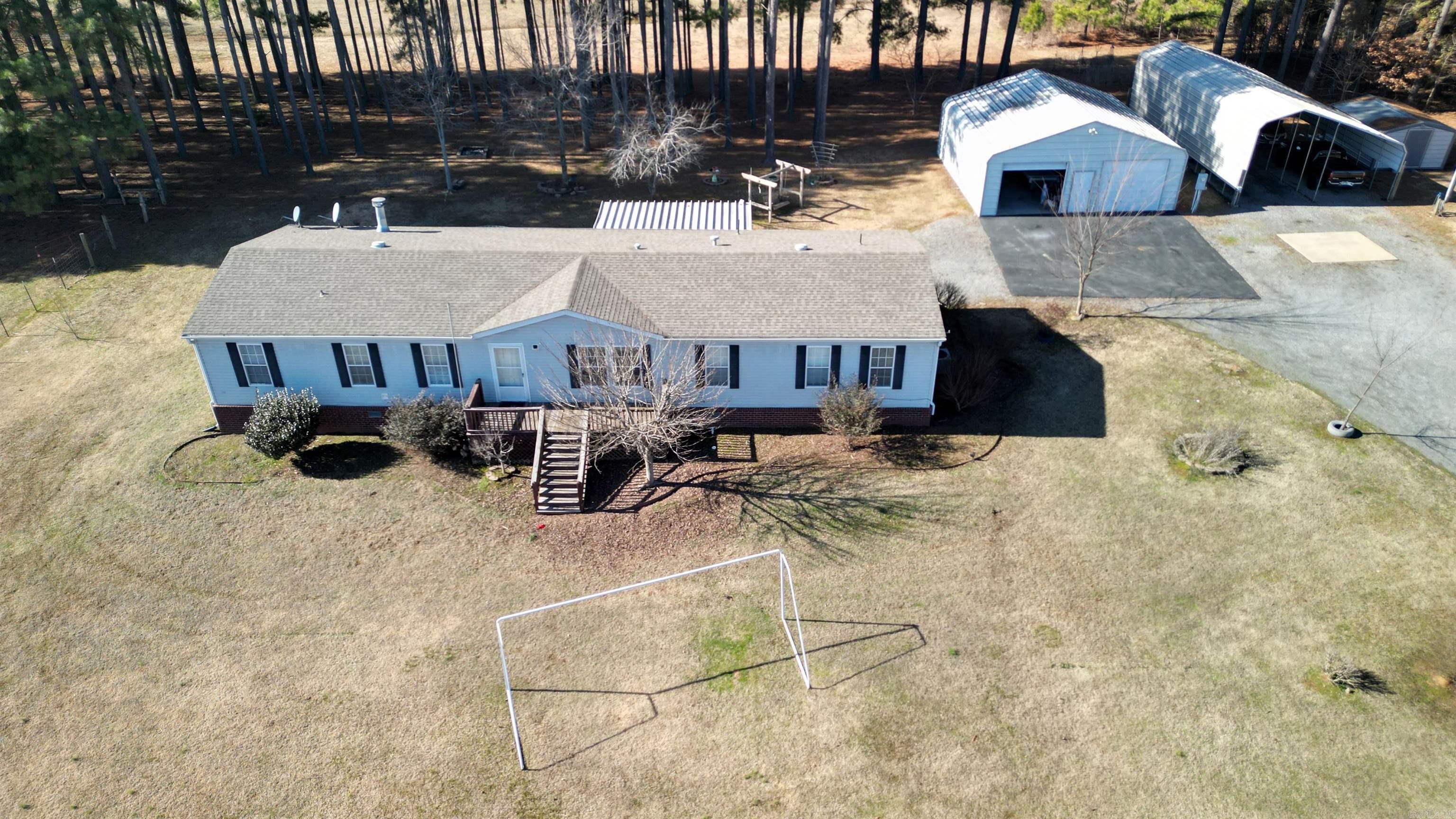 Take a look at this beautiful piece of property. The mobile is a doublewide with 4 bedrooms and 2 bath. Primary has its own sitting area/office space. Primary bathroom has a wonderful soaking tub along with a separate shower and a large walk in closet. Home has a large living room and a large separate den with a wood burning fireplace. The land is gorgeous! Lots of open areas and a large pond with a dock to enjoy a peaceful day of relaxation. There are 3 separate deck areas off the back of the home and one is screened in so you can enjoy your evenings on your back deck with no bugs! One area is set up for you to have your own pool if you choose to do so! Property also includes a 30X30 Utility building, small storage shed, double carport, a chicken coop, a large dog pen, and a storm shelter. Come check out this little piece of heaven in a high demand area! It won't last long, don't miss out!!