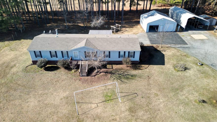 Take a look at this beautiful piece of property.  The mobile is a doublewide with 4 bedrooms and 2 bath. Primary has its own sitting area/office space. Primary bathroom has a wonderful soaking tub along with a separate shower and a large walk in closet. Home has a large living room and a large separate den with a wood burning fireplace. The land is gorgeous! Lots of open areas and a large pond with a dock to enjoy a peaceful day of relaxation. There are 3 separate deck areas off the back of the home and one is screened in so you can enjoy your evenings on your back deck with no bugs! One area is set up for you to have your own pool if you choose to do so! Property also includes a 30X30 Utility building, small storage shed, double carport, a chicken coop, a large dog pen, and a storm shelter. Come check out this little piece of heaven in a high demand area! It won't last long, don't miss out!!