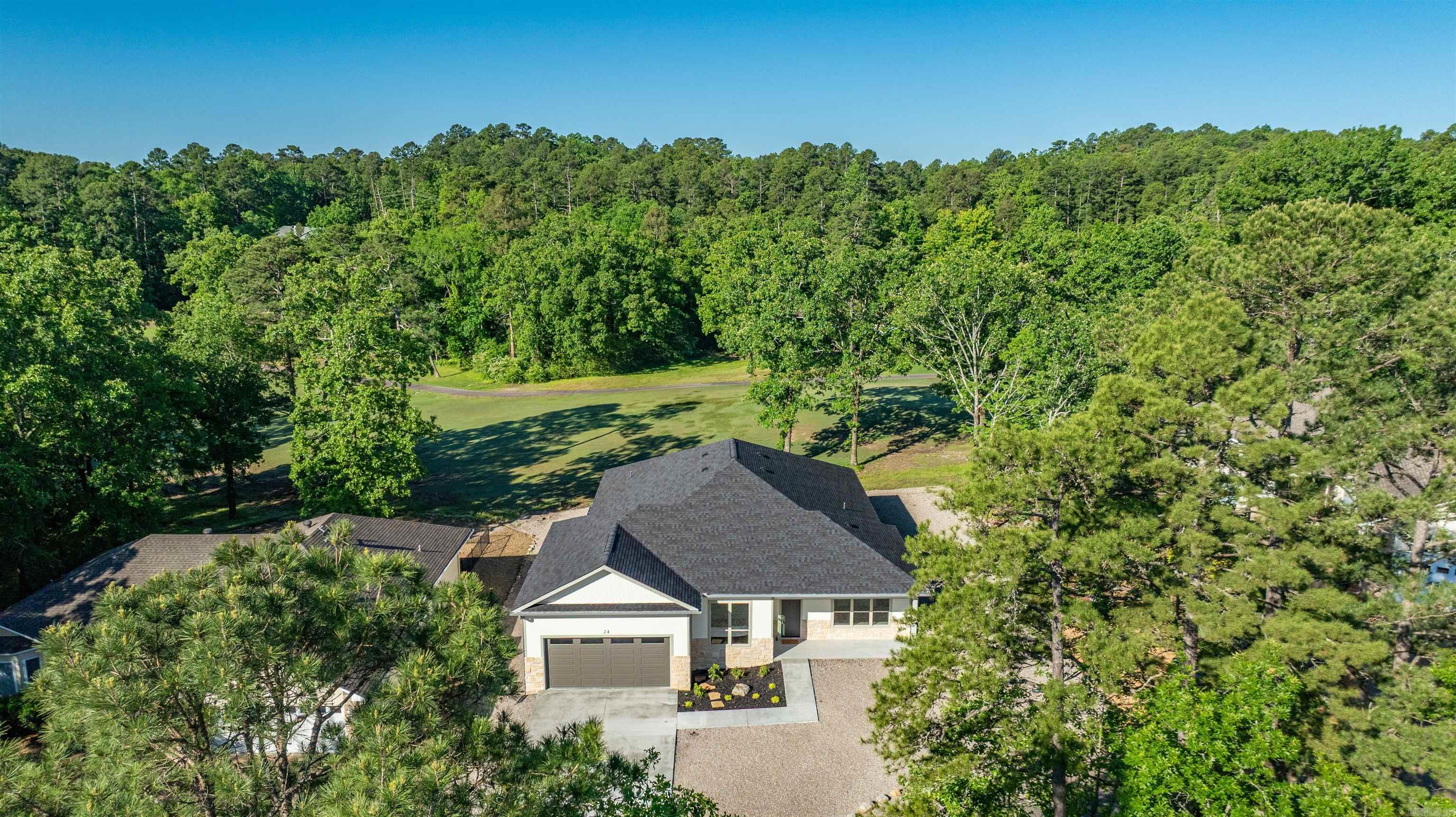 Escape to your own private oasis on the Golf Course in Hot Springs Village, Arkansas! This stunning new construction home offers an unparalleled lifestyle of luxury and tranquility. Step inside and be captivated by the modern elegance and thoughtful design. The open-concept floor plan is perfect for entertaining, with a spacious living area that flows seamlessly into a gourmet kitchen. Imagine preparing meals in a chef's dream kitchen, complete with high-end appliances, a large quartz island, and a large pantry.Floor-to-ceiling windows flood the home with natural light and provide breathtaking, panoramic views of the Coronado golf course. From your living room, primary bedroom, or covered back patio, you'll feel as though you're a part of the pristine landscape. The primary suite is a true retreat, featuring a spa-worthy bathroom with dual vanities and an oversized walk-in shower. Living on the Golf Course means you're not just buying a home, you're buying a lifestyle. Enjoy easy access to the Coronado Fitness Center, tennis and pickleball courts, and of course, the scenic 18-hole golf course. Agents please see remarks and see the features sheet in associated documents.