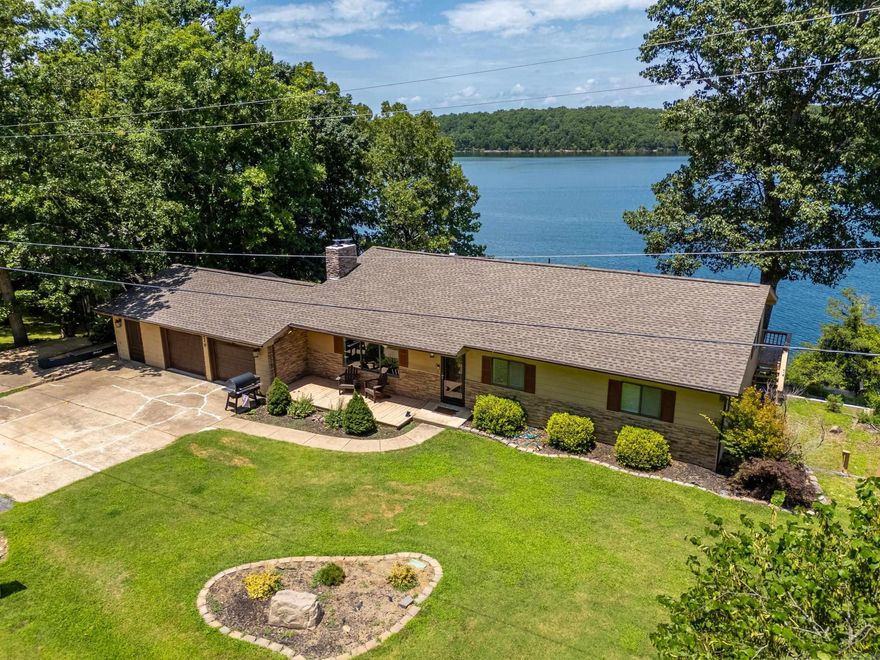 Discover your dream retreat with this beautifully updated lake home boasting an unbelievable view of Bull Shoals Lake! Perfectly positioned at the end of a quiet dead-end street, this spacious 4-bedroom, 3-bath home offers peace, privacy, and direct access to the government strip—just a short walk to the water. Inside, you’ll find a stunning open-concept floor plan with a top-of-the-line kitchen that flows seamlessly into the dining and living areas. The main level also features 2 bedrooms, 2 full baths, an office, and a large lake-facing deck ideal for entertaining or soaking in the view. The fully finished basement includes a sunroom with walkout access to a patio, a family room with a cozy fireplace, a second kitchen with eat-in dining, laundry area, 2 more bedrooms, and a full bath—making it perfect for guests or multi-generational living. A heated and cooled 2-car garage completes this incredible package. This home has been pre inspected and also comes with a 14 month home warranty. Don’t miss the chance to own a piece of lakefront paradise!