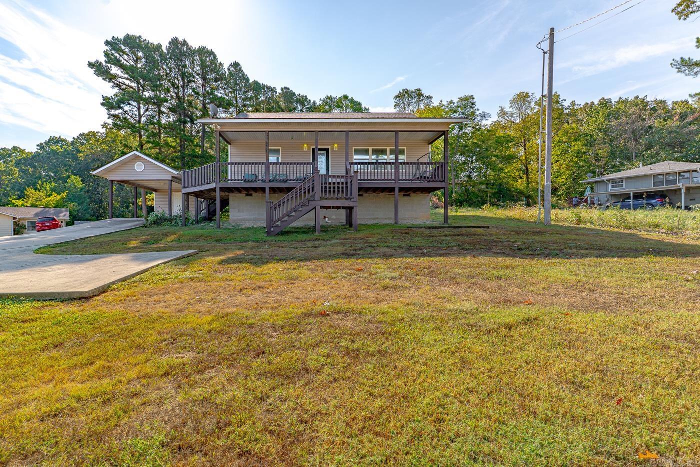 Welcome to the market another Compass Rose Realty Exclusive property, located at 14 Yosemite Dr. in Cherokee Village Arkansas. Upon entering the home you will see a well laid out kitchen/dining space. There is a breakfast bar with plenty of space too! You will find trayed ceiling in the living room with a secondary free standing fireplace. There is also a beautiful wrap around porch that you can access through both the living room and kitchen! All three bedrooms are extremely spacious providing plenty of room for everyone. The guest bath is also bigger and tons of storage. The master bedroom and bathroom have ample space and there is also a walk in closet in this room. There is a utility room for laundry as well! There is a storage building in the back as well as smaller storage space with the detached carport! This home is turnkey ready! Call today to make an investment tomorrow!