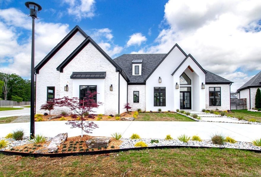 Discover luxury living in prestigious gated West Lake Village with this newly constructed gem. Boasting an open-concept main level that features three well-appointed bedrooms on the main level, along with a versatile office space, a state-of-the-art kitchen, and a cozy living room complete with a modern linear fireplace and hearth. The kitchen is a chef's dream with a waterfall island, high-end white and gold café appliances, a professional gas range, and an expansive walk-in butler's pantry. The primary suite is a true sanctuary, offering a breathtaking bathroom with dual vanities, backlit mirrors, a magnificent walk-in shower, and a vast closet. Upstairs, find a bonus room or additional bedroom alongside a full bathroom, perfect for guests or as a private retreat. Every detail exudes elegance, from the custom lighting to the premium tiles and fixtures. The property also includes a three-car garage, full irrigation system, and a stunning back porch with a vaulted ceiling, ideal for enjoying serene evenings. Pool rendering photos are not actual photos of yard but show what could be done if desired. Conveniently located within the Bryant School District and only minutes from I-30!