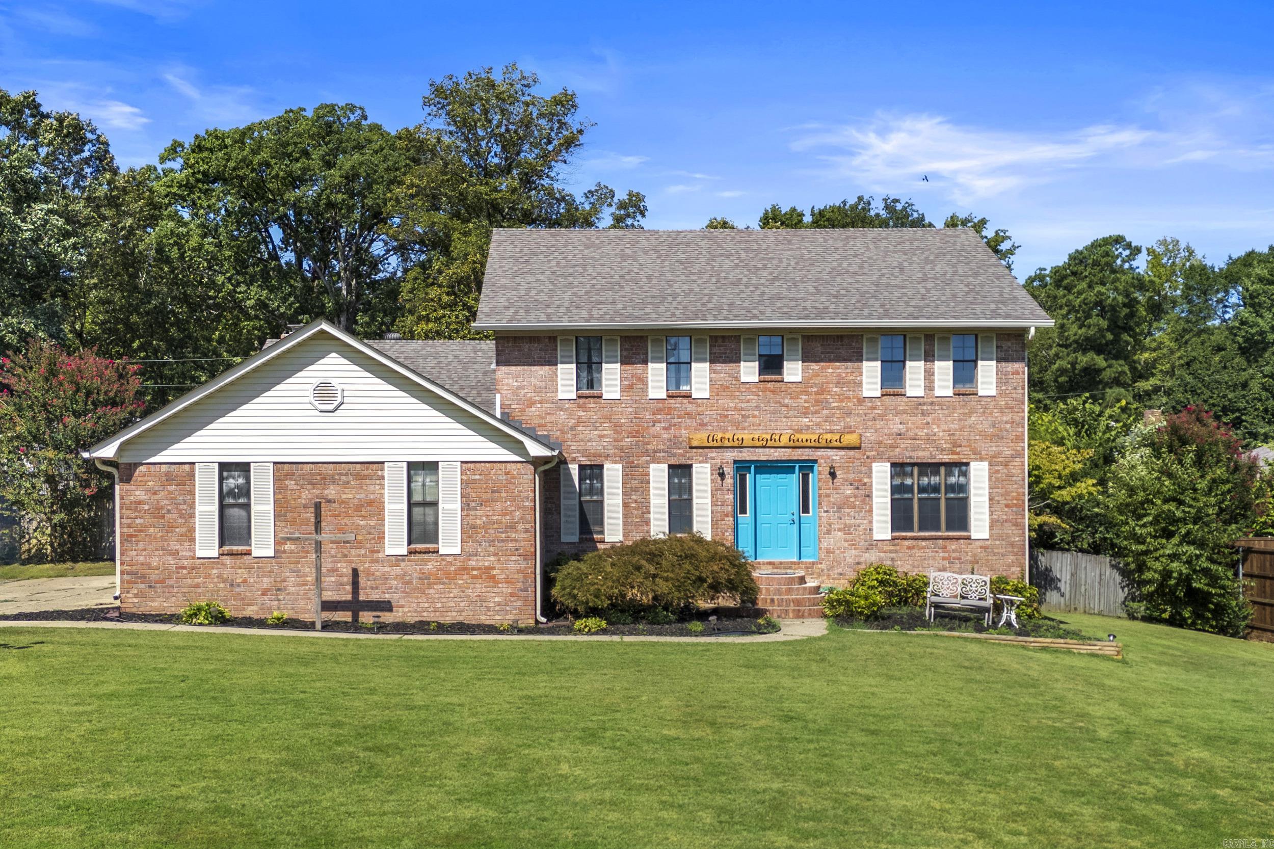 Welcome to this spacious 5-bedroom brick home featuring classic charm and modern updates. Inside, you'll find a warm living room with wood beamed ceilings, a cozy brick fireplace, and built-in shelving that creates a perfect gathering space. The home also includes a closed sunroom, ideal for year-round enjoyment, and a finished basement offering endless possibilities for entertainment or extra living space. Outside, the beautifully maintained yard and striking blue front door add curb appeal, while mature trees provide shade and privacy. This home combines comfort, character, and plenty of room to grow - ready for its next chapter.