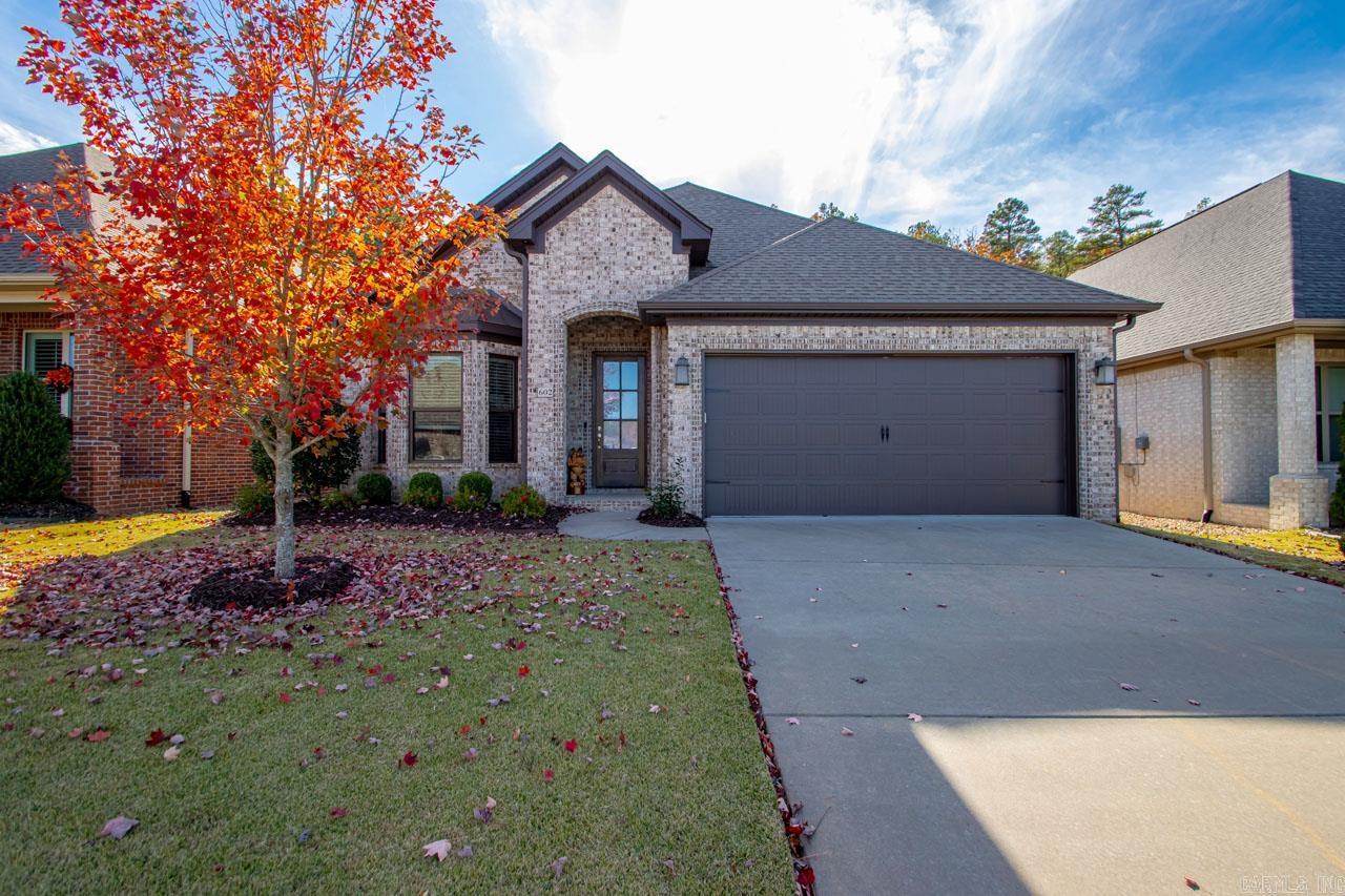 Discover the allure of this single-level residence nestled in the coveted Wildwood Place of West Little Rock. As you step onto the inviting covered front porch, the seamless flow of hardwood floors guides you through the expansive open floor plan. To the left, a formal dining area effortlessly transitions into the well-appointed kitchen featuring a granite breakfast bar, built-in gas stove, pantry, and a refrigerator that conveys with the property. The generously sized living area, adorned with a gas log fireplace, seamlessly connects to the kitchen. The primary suite is a private haven, boasting a double vanity, walk-in shower, jetted tub, and a spacious walk-in closet. Two additional bedrooms share a tastefully designed bath. Step outside to the covered patio and relish the level backyard that abuts protected green space, enhancing your connection with nature through an elegant iron fence. The wonderful community amenities include a neighborhood pool, playground, picnic area, and more, ensuring a lifestyle of comfort and leisure.