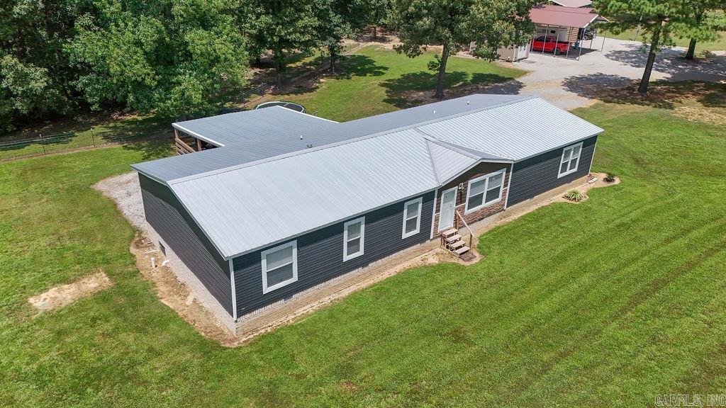 This 4-bed, 2-bath home on nearly 21 acres offers comfort, space, and country charm. Enjoy luxury vinyl flooring throughout and a living room with built-ins, a large electric lava rock fireplace, and ceiling beams. The spacious kitchen features two islandsāone for prep and one for seatingāplus a walk-in pantry. The laundry room includes a soaking sink, and thereās a separate den for added living space. The large primary suite boasts a walk-in closet, double vanity, dressing table, oversized shower, and soaker tub. The second full bath also includes a double vanity, soaker tub, and separate shower. An oversized covered deck provides the perfect spot to relax or entertain. The home is on a permanent foundation with stone and brick skirting. Outside features include a large workshop, RV-sized carport, additional storage buildings, and a barn with 3 stalls, tack room, and round pen. Thereās also an open-side shed great for selling produce. Approx. 8 acres are cleared, with 13 acres wooded with a natural spring and deer. (Agents - PLEASE read Agent Remarks)