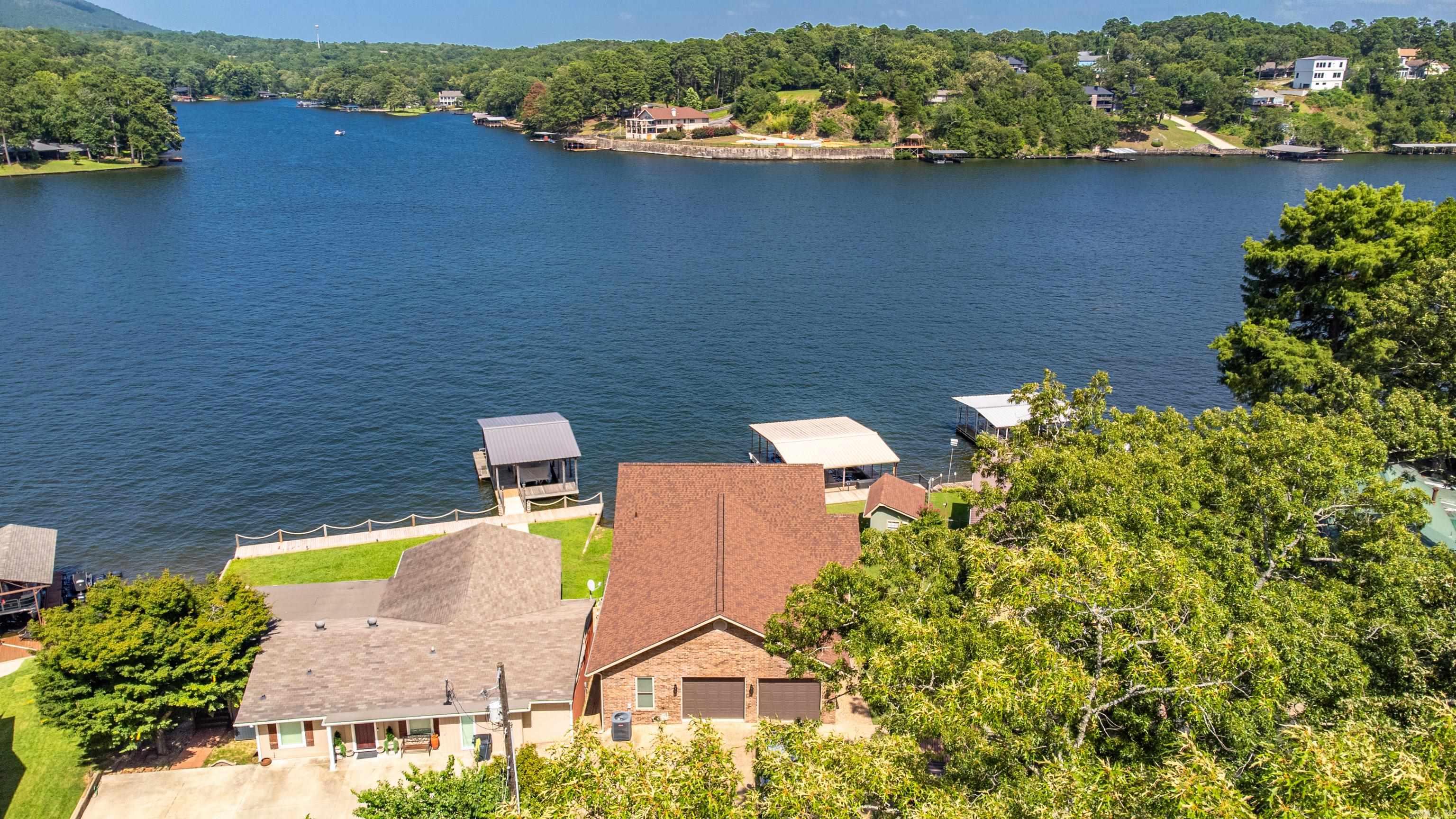 Welcome to 220 McDonald Loop ā A stunning Lakefront Retreat with Guest House on the Main Channel Built in 2007, the main home features 3 bedrooms and 2.5 baths, 1794 sq. ft. thoughtfully designed for comfort, entertaining, and lakefront living at its best. Step inside to find rich hand-scraped wood floors and a bright, open-concept layout. The kitchen is both stylish and functional, featuring granite countertops, quality cabinetry, and plenty of prep space for hosting family and friends. A dedicated laundry room and an oversized 2-car garage add to the homes functionality, while large windows capture sweeping water views. Outdoors, enjoy your morning coffee or evening sunsets from your private lakeside deck. Boaters will appreciate the covered double boat slip with two lifts, providing direct access to the lakeās main channel. Bonus Feature ā Private Guest House! Included with the property is a separate guest house built in 1996, offering 792 sq ft of living space. This one-bedroom, one-bath guest home includes a full kitchen, a comfortable living area, and its own back deckāperfect for guests, extended family, or potential rental income.