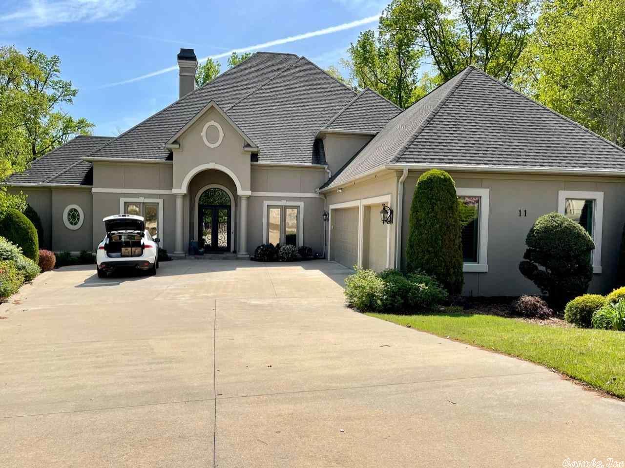 Lovely custom home built by Malinda Marcus - 9', 10', 12' ceilings, travertine floors, exquisite detailing, heated and cooled 3 car garage.  Bank of windows across the back of the house overlooking wooded area.  Kitchen opens into den, master suite is large with incredible closet.  Has an office, balcony on rear and spacious patio.  Gated community.  Tremendous storage, master down with 2 guest up with sitting room.