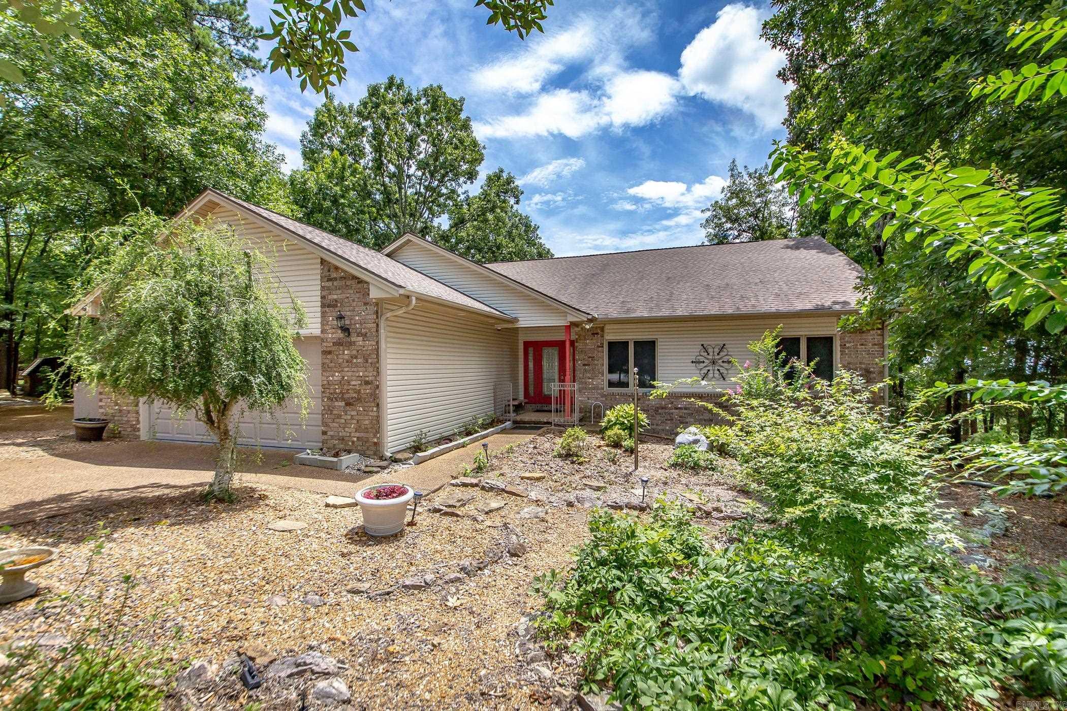 Discover the perfect blend of comfort & convenience in this beautiful home, ideally situated on a spacious corner lot with views of Greers Ferry Lake & the mountains. This home boasts an open floor plan that seamlessly connects living, dining, & kitchen spaces—ideal for both everyday living & entertaining. The updated kitchen features granite countertops, newer appliances, & ample storage, creating a welcoming hub for family gatherings & meal prep. Two bedrooms offer seating areas—perfect for guests or quiet relaxation. The front bedroom is a true highlight, featuring a spacious walk-in closet for all your storage needs. Step outside to a large, fenced area—perfect for gardening enthusiasts. There are include multiple outbuildings for storage or hobbies, & abundant parking for vehicles, boats, or RVs. The lower level room would make an excellent home office, studio, or fitness area. During cooler months, gather around the inviting wood-burning fireplace in the living area. An oversized garage provides plenty of storage space, while the quiet, walkable street offers a peaceful setting for walking or bike rides. Enjoy all the amenities of the Bay: golf, pickle ball, & the lake access