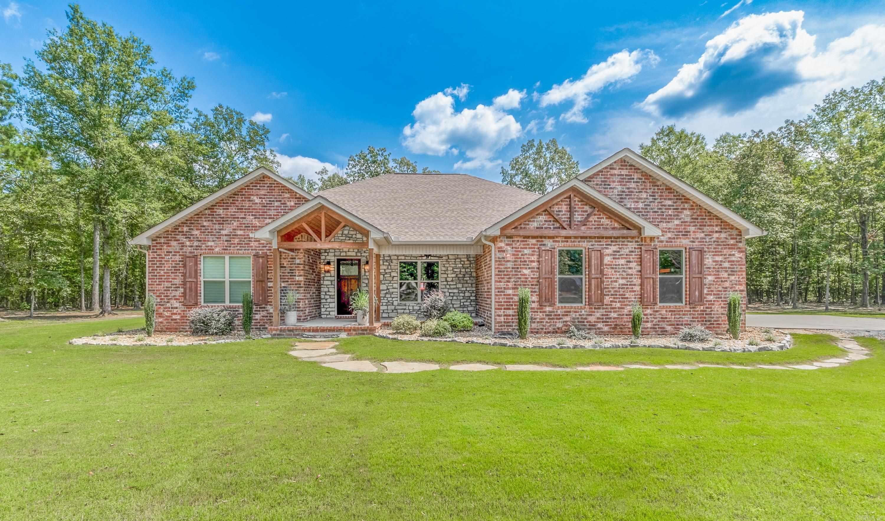 This beautiful 4 bedroom/3 bath home is ready for you to call home. Situated on a lovely wooded 5 acre lot, this stunning property is move-in ready. As you step inside, you'll be greeted by extra wide doors throughout. The home features a front great room with exposed beams and a gas log fireplace. The kitchen area has a beautiful chandalier for over a dining room table. The spacious kitchen with an extra large island makes for a breakfast bar and is perfect for gatherings. The kitchen offers tons of cabinets, granite countertops, free standing range w/doublee, refrigerator, and vent a hood. The expansive owner's suite with a large bath that includes a large shower, separate soaking tub, large closets, and double vanities. There are three additional spare bedrooms, one with a private bath, and a Jack & Jill bath. Wonderful home for any family and 5 wooded acres are exceptional!
