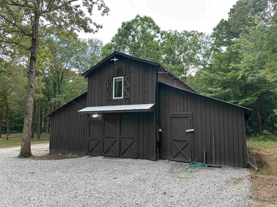 This versatile 10-acre m/l property is located just 10 minutes west of Searcy in the highly desirable Ozark Foothills. Whether you're dreaming of a private hunting retreat, a small hobby farm, or a peaceful country homesite, this property has the flexibility to suit your needs.  The property features 640 sq. ft. of heated and cooled living space on the upper level, complete with a furnished living room, kitchen, bedroom, bathroom, and laundry area — perfect as a weekend getaway, full-time residence, or while building your dream home. Enjoy the views and wildlife watching from the second-story deck, where deer, wild turkey, and small game are regular visitors.  The lower level includes an office and spacious enclosed storage, ideal for farm tools, outdoor gear, or workshop space.  Additional acreage available.  (agent owned)