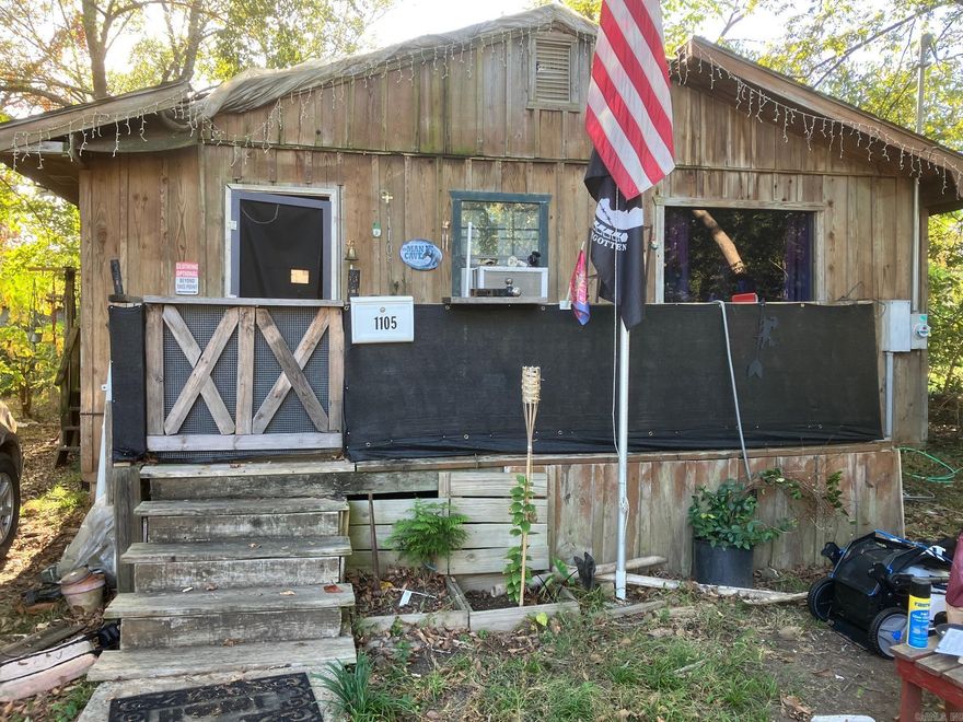 2 bed / 2 bath batt & board cabin style home with a nice front porch located in Original Mena neighborhood that is convenient to all things in downtown Mena and soon to be very convenient to the new bike trails! Lot with nice shade trees in the back yard.  Price point reflects the need for a new roof and some drywall ceiling patching inside, along with needing interior updates and cleaning. Once done, it will be a really nice home or rental property. Second bath has a large corner whirlpool tub and needs finish work. All Appliances stay. Refrigerator, Range and Washer/Dryer. Neighborhood has lots of homes being currently renovated!