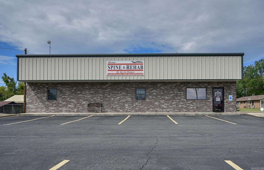 This commercial business location is in a highly visible and densely populated area of Mena, making it ideal for your new venture. The .32 acre property is complete with signage, asphalt parking lot, and landscaping. The main feature is an immaculately kept 32x60 steel building with awning and brick face. Superior soundproofing with spray foam insulation on the exterior walls and fiberglass inner insulation contributes to peace and quiet in this well-insulated space. Inside you will discover a reception area, kitchen, large open floor space, 4 rooms with sinks, an office room that includes a full bath with walk-in shower, plenty of storage, utility space with washer/dryer hook-up, and security system.