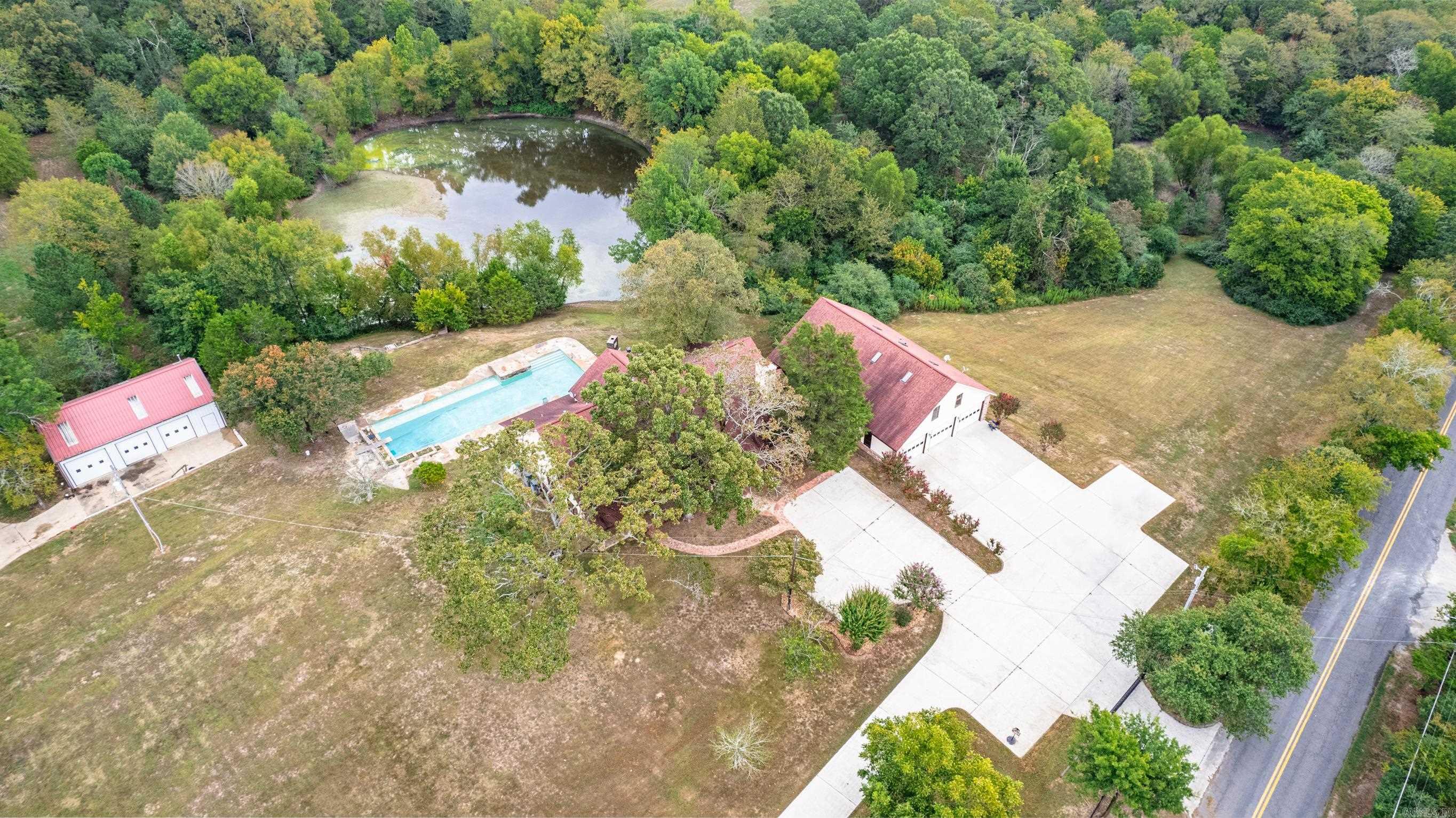 Nestled amidst the serene beauty of Hot Springs, Arkansas, this remarkable property offers a unique blend of modern amenities and rustic charm, making it a retreat for those seeking an unparalleled lifestyle. Situated on sprawling grounds, this estate spans over an impressive landscape, boasting a stocked pond, 3 bay shop, small horse barn, and huge 6 car garage with apartment over top. The centerpiece of this estate is undoubtedly the stunning pool, where you can indulge in endless summer days of leisure and entertainment. Whether you're swimming laps, hosting poolside gatherings, or simply basking in the sun on the spacious deck, this oasis is a haven of relaxation and rejuvenation. The property is fully fenced with 2 private gated entrances. Just minutes from downtown, and everything Hot Springs has to offer yet tucked away on you own private estate. Call us for a showing to your next home.