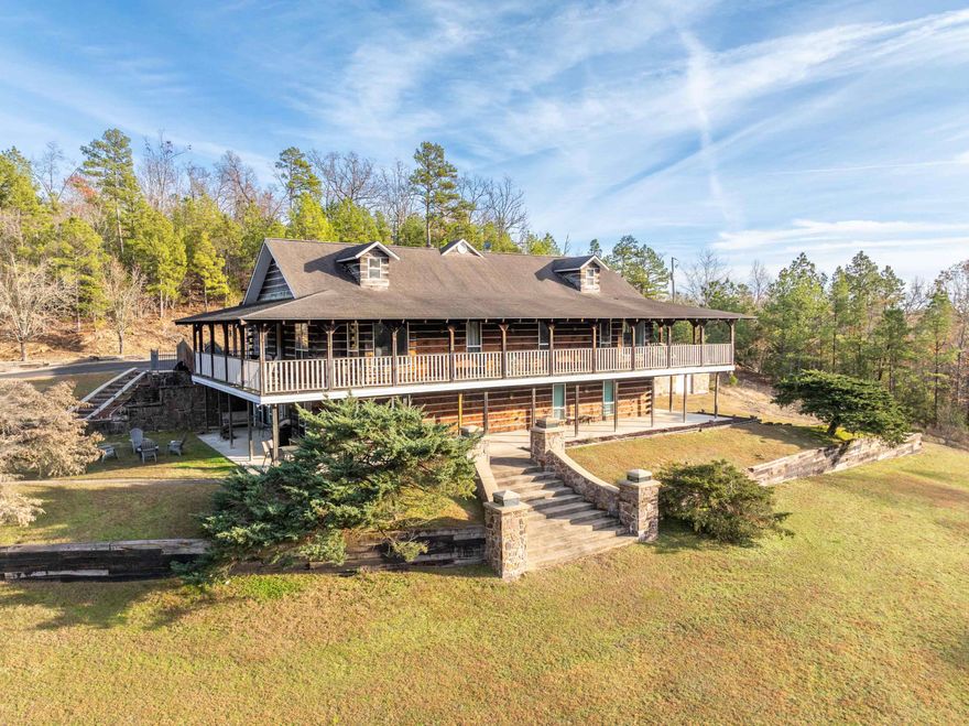 Experience the epitome of mountain living in this majestic hilltop lodge. The driveway greets you with custom stone & iron fencing, illuminated by elegant lighted pillars; and the gated grand entrance sets the tone for the outdoor living areas, encompassing over 3.47 acres. You'll love the beautiful in-ground pool surrounded by mountain views, a covered cabana with grill for outdoor dining, a fire pit area for evening gatherings, and the tranquil Old Bear Creek winding through a portion of the estate. Inside, the cozy lodge ambiance envelops you as the main level features open-concept living with gleaming hardwood floors, a gas fireplace, a wet bar perfect for evening cocktails, & a spacious kitchen equipped with a gas cooktop. The master suite exudes vintage charm & features a large walk-in closet & private access to the wrap-around deck. Additionally, the main level includes a guest bedroom & full bath. The lower level offers versatile space, including a kitchenette, an additional bedroom with patio access, a full bath, & a heated/cooled double garage with stained concrete floors. Located just 10 minutes from Lake Ouachita and Brady Mountain Resort, this property is a rare gem.