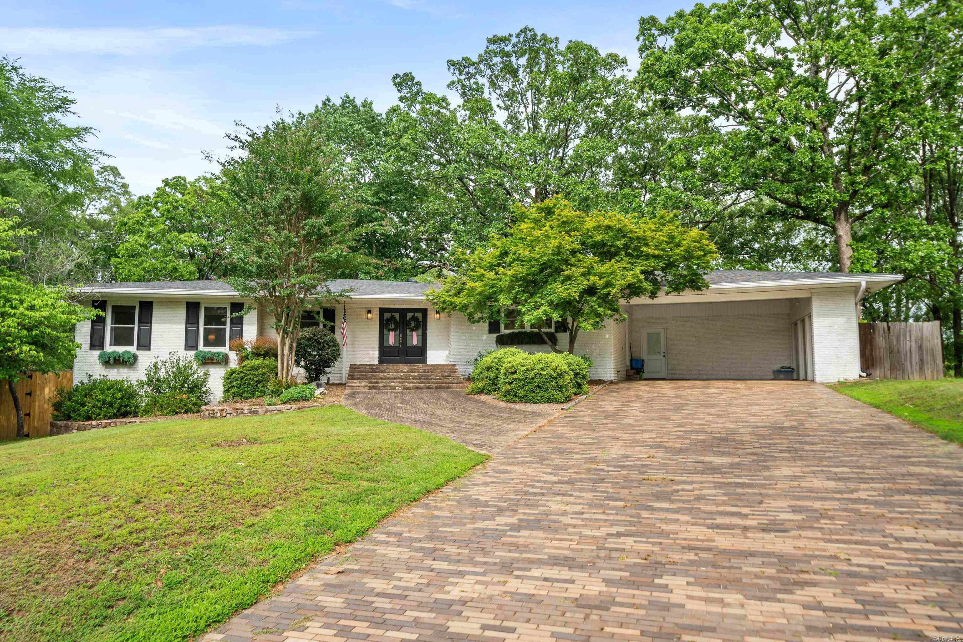 Nestled in the heart of the highly desirable Lakeside School District, this remarkable 4-bedroom, 3-bath home offers a rare opportunity to own a piece of local legacyāthe former residence of Verna Garvan, one of Hot Springsā most influential figures and namesake of Garvan Woodland Gardens. From the moment you arrive, youāll be captivated by the charm and craftsmanship that define this home. A unique wrap-around exterior built with custom-made bricks sets the tone for the timeless quality youāll find inside. Step through the front door into a spacious step-down living room highlighted by an impressive floor-to-ceiling brick fireplace and hearth, perfect for cozy evenings or gathering with family and friends. Throughout the main level, original hardwood floors create warmth and character, beautifully preserved yet complemented by modern updates. The kitchen has been fully renovated, featuring sleek cabinetry, solid-surface countertops, and contemporary appliancesāideal for everyday living or entertaining. The homeās lower level offers versatility and privacy, with a second living area, separate exterior access, an additional bedroom and full bath, and tons of storage.