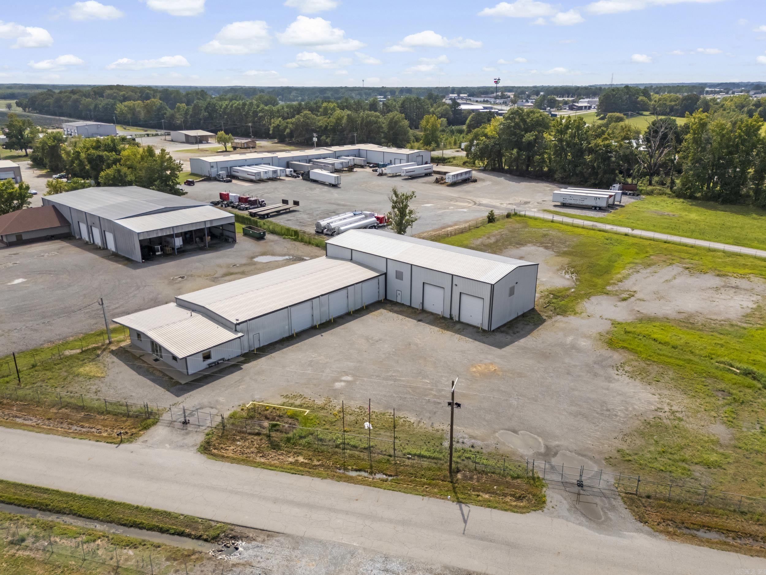 Fabulous new listing with unlimited possibilities for the space. 11,650 sq feet of work area plus lockable housed air compressor unit room. 1,000 sq ft of high end central heat and air office space with stained concrete flooring, private bathroom with shower area in office space. Fully furnished break room, full safe room with 6 " thick door. 3 phase electrical service. 10 ton power trolley bridge crane, wash bays with oil and water separator. Heavily graveled lot with 4 entrance/exits for 18 wheeler traffic. Three 14' tall power lift doors, four 16' tall drive through bays with power lift doors. Shop area has multiple synchronized control power louvers and 5' cross ventilation fans. Infrared heaters throughout. Multiple 220 outlets , one three phase outlet, multiple air drops, and 110 outlets throughout. Easy on and off Hwy. 67-167 exit and sitting on city limit boundary, just outside of city limits.