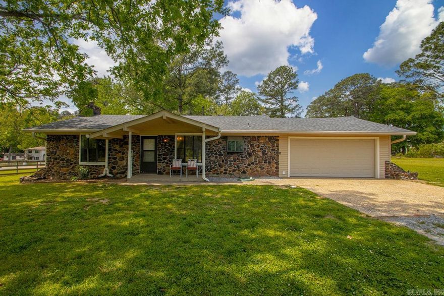 Run, don't walk to see this one! Just look at this gorgeous yard and these trees! This adorable 3 bedroom 2 bath home featuring several updates including master bath with new shower, vanity and flooring.  The large living area is versatile, inviting the entire family in to gather around the stunning stone fireplace.  The kitchen features stainless steel appliances and butcher block countertops.  The roof is less than 2 years old and the garage door is also new.  Step outside to the most gorgeous lot with mature trees and surrounded by green spaces...and all of this on almost an acre in town and close to everything! Don't miss your opportunity to own this little piece of paradise and all for less than $200,000!