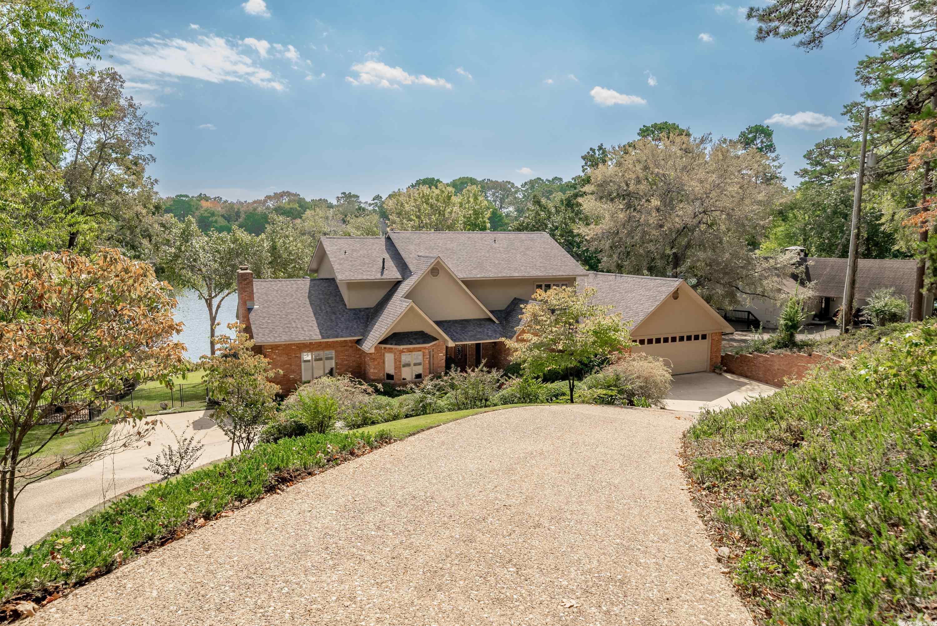 The LAKE HAMILTON GEM YOU'VE BEEN WAITING FOR! Walls of windows bring the outside in and provide awe-inspiring lake views from most every room. The main level features a primary ensuite, 2 livings areas, formal dining and office.  Upstairs offers an additional ensuite bdrm and 2 guests rooms with bath. Guests will come together at the expansive deck area, heated/cooled pool and fantasitc outdoor kitchen with additional 1/2 bath. 149' of lake frontage and a 2 stall boat dock. This list goes on with this one!