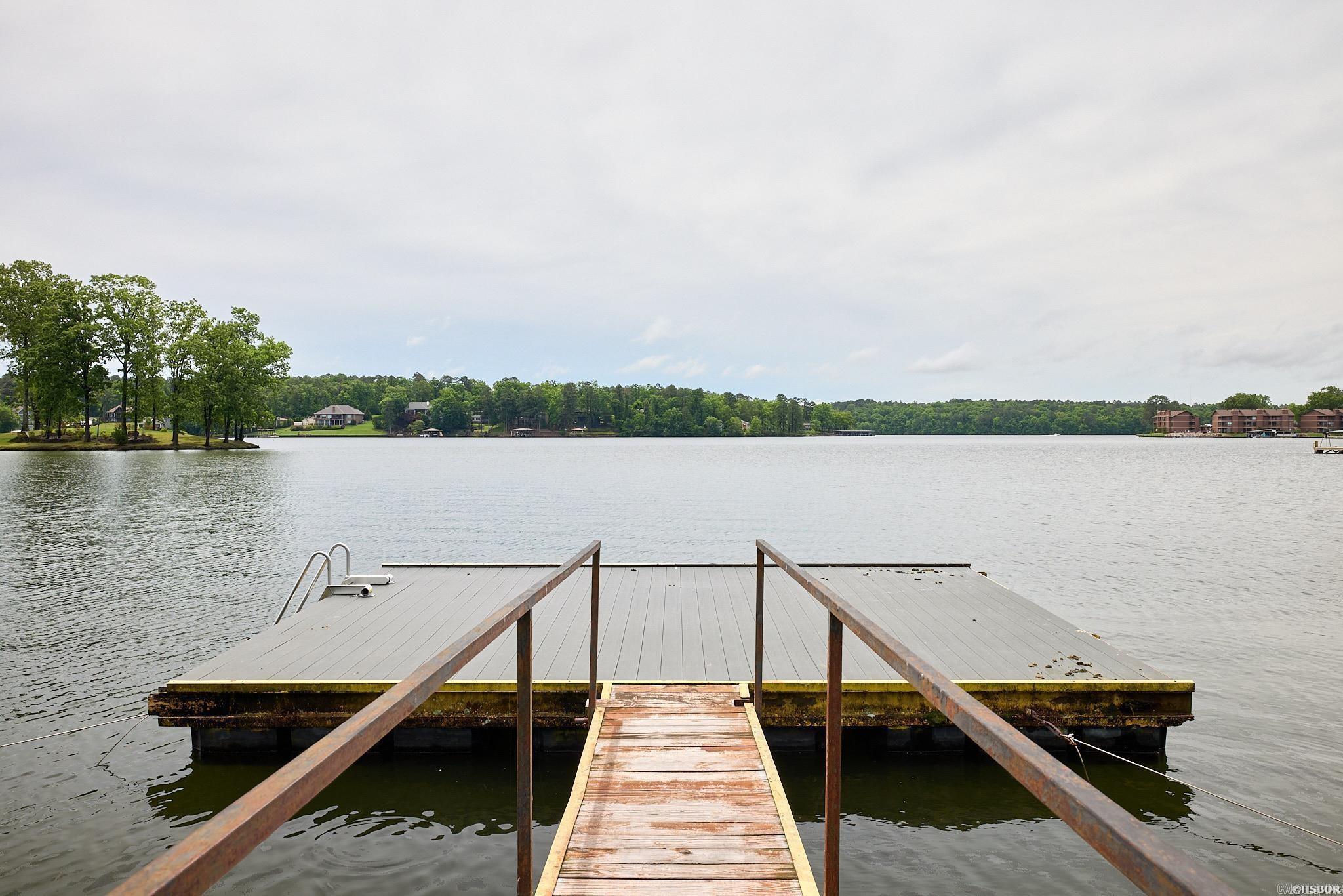 Unlock the potential of this exquisite short-term rental - a fully furnished, turn-key condo nestled on the shores of Lake Hamilton, conveniently situated within the city limits of Hot Springs. Explore the vibrant Historic Downtown Hot Springs scene or indulge in the excitement at Oaklawn, all within a stone's throw from your new investment. This lakefront property comes complete with high-quality furnishings, ensuring a hassle-free transition for you and potential renters. The stylish kitchen boasts granite counters and a complementary backsplash, adding a touch of luxury to the living space. Enjoy breathtaking views of Lake Hamilton right from your doorstep. Take advantage of the boat ramp for easy access to the lake, enhancing the overall experience for residents and guests. Enjoy the salt-water pool on hot afternoons. Currently a Short-term-rental.