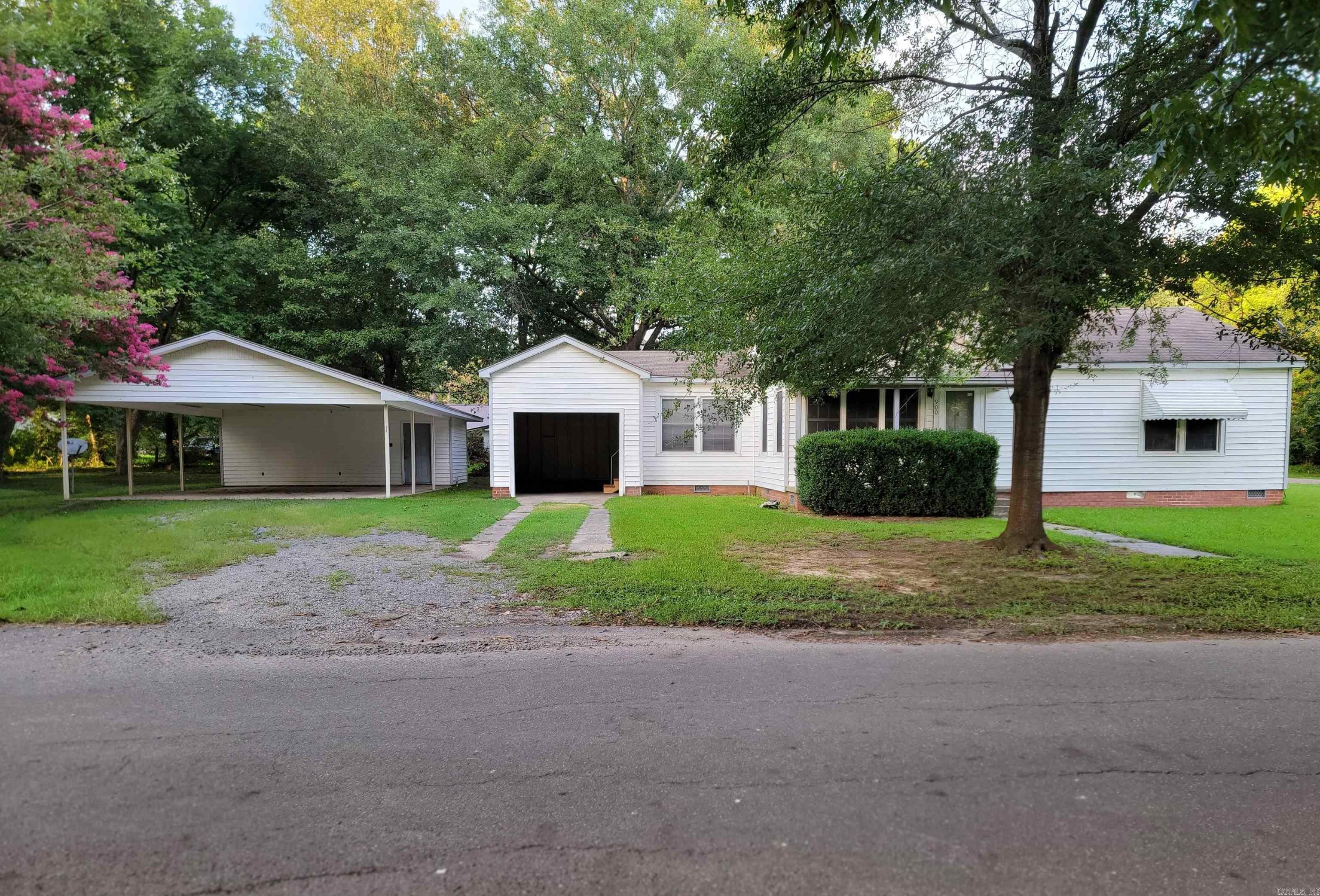 Move-In Ready! This very nicely restored 2-bedroom, 1-bath home offers 1,156 square feet of comfortable living space, perfectly situated on a little over two lots, located on a corner. Whether you're a first-time buyer, a couple, or a small family, this home is a fantastic opportunity. Property Features Include: New electric surface range; New stainless steel refrigerator; Double-pane windows for energy efficiency; Hall bathroom with a tub/shower combo, with large storage cabinet; Detached double carport - 24x29 ft.; Detached double carport storage room with A/C unit - 24x11 ft. (264 sq. ft.); Large, shaded backyard with 4' chain-link fencing—perfect for kids, pets, or entertaining; All-new flooring: durable vinyl plank and vinyl throughout, over original hardwood flooring; New water heater; Front porch with concrete flooring; Patio is just outside the back door and behind the garage back wall; Single open garage with door to the house and outside patio; Additional storage room accessible from the patio; Small metal storage building at the back of lot; Don't miss the chance to make this inviting home your own—schedule a showing today!