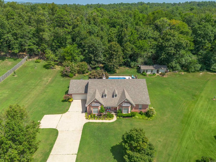 Located just minutes from the heart of Hot Springs, this thoughtfully updated 4-bedroom, 3-bath home offers generous space, functional layout, and stylish upgrades throughout - all complemented by a private backyard oasis.  Featuring four generously sized bedrooms, this home offers exceptional flexibility. One bedroom and full bath are situated on the opposite side of the home from the others, creating the perfect opportunity for a private guest suite, in-law quarters, or ideal teen retreat.   The kitchen showcases new cabinetry and appliances, while new LVT flooring and fresh carpet in the living room and primary bedroom add warmth and durability. A versatile sitting room offers endless possibilities — whether you envision a formal dining, home library, or office space.  Major updates provide peace of mind, including a new roof (2023) and new pool liner (2024). Step outside to enjoy the screened-in back porch and newly installed Trex decking (2024), perfect for year-round relaxation and entertaining.  The backyard is an oasis featuring a sparkling in-ground pool, lounging area, and beautiful landscaping. An outbuilding offers extra storage or perhaps a future pool house.