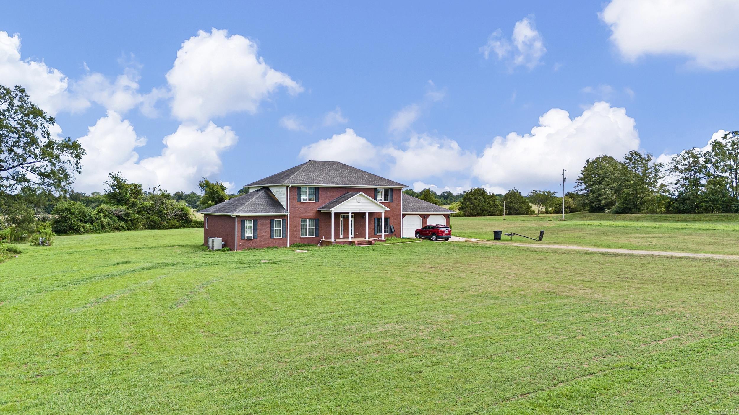 Welcome to your dream retreat! Nestled in a quiet subdivision just minutes from Dardanelle and located in scenic Yell County, this beautifully crafted custom home offers the perfect blend of privacy, comfort, and convenience. Situated on 6 spacious acres, the property features a private pond, level land, and plenty of room to roam or expand. Built in 2013, this two-story residence showcases quality craftsmanship and thoughtful design throughout. Step inside to soaring high ceilings, rich hardwood flooring, and elegant tile finishes that set the tone for upscale country living. The open-concept layout provides generous living spaces, while large windows fill the home with natural light and stunning views of the surrounding landscape. Each of the four oversized bedrooms offers ample closet space and room to relax, making this home ideal for families, guests, or even a home office setup. Whether you're enjoying a quiet evening on the porch or hosting gatherings in the spacious living and dining areas, this home is designed for both comfort and entertaining.