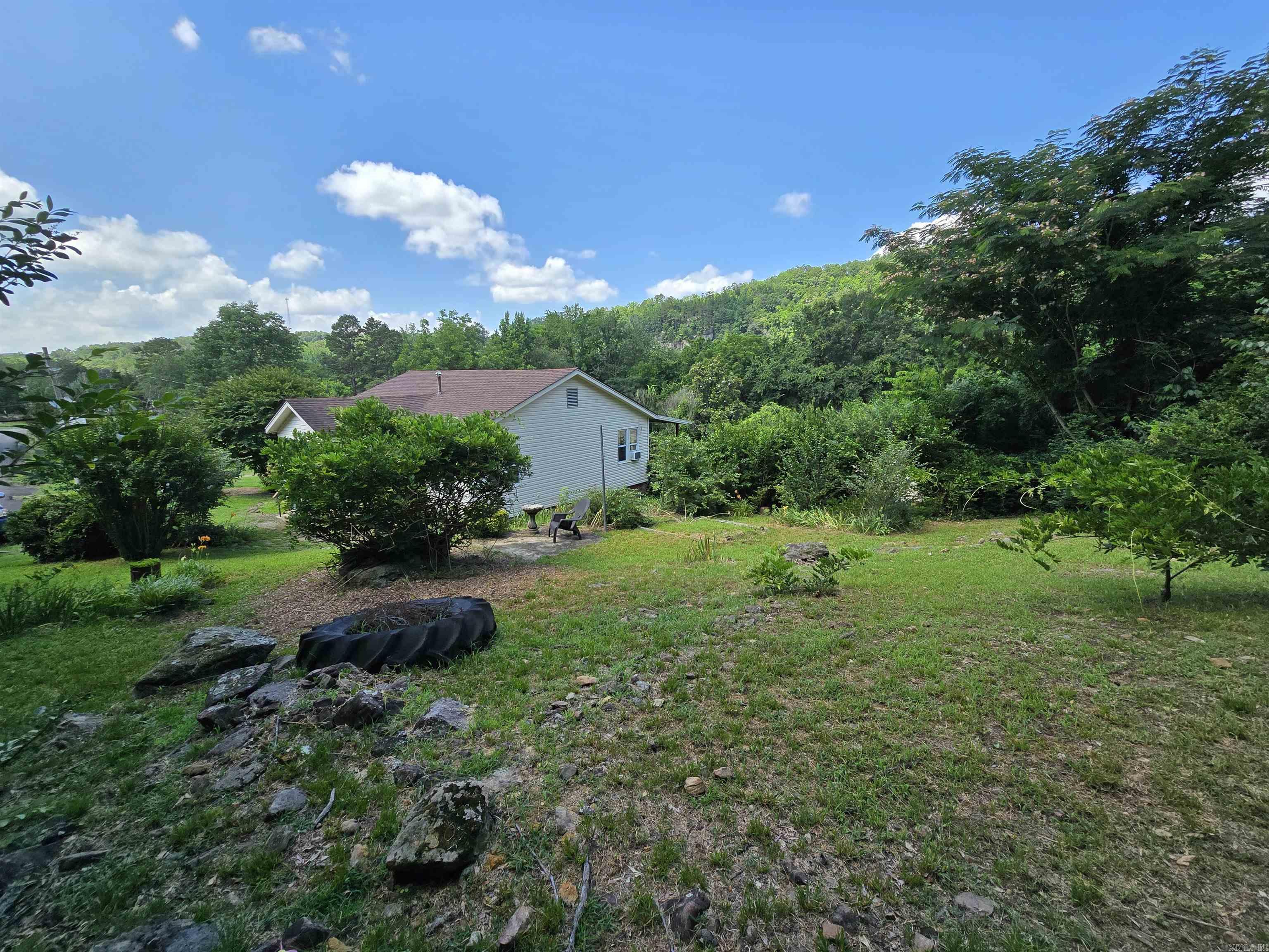The chance of a lifetime! Private, peaceful living on 5 unrestricted acres with approximately 500ft of frontage on the middle fork of the Little Red River. Paddle right up to the property! Historic parcel features move in-ready cottage with fenced backyard and covered back porch overlooking the pasture below and the mountain bluff across the river. Perfect for morning coffee as the fog rises from the river. Tasteful updates throughout address modern living while preserving its unique historic charm. The southern acreage has been perc tested and has a mobile that is ready for completion. This space could also be used for RV hookups, more pasture for hobby farming, or other potential income generating activities. Situated on a brand new blacktop road, this is just 15mins from the Fairfield Bay marina, 90 miles of UTV trails, hiking, biking, and all of the amenities Greers Ferry Lake area. Come take a look. Don't regret missing your shot at owning real walkable river access on this little slice of paradise.