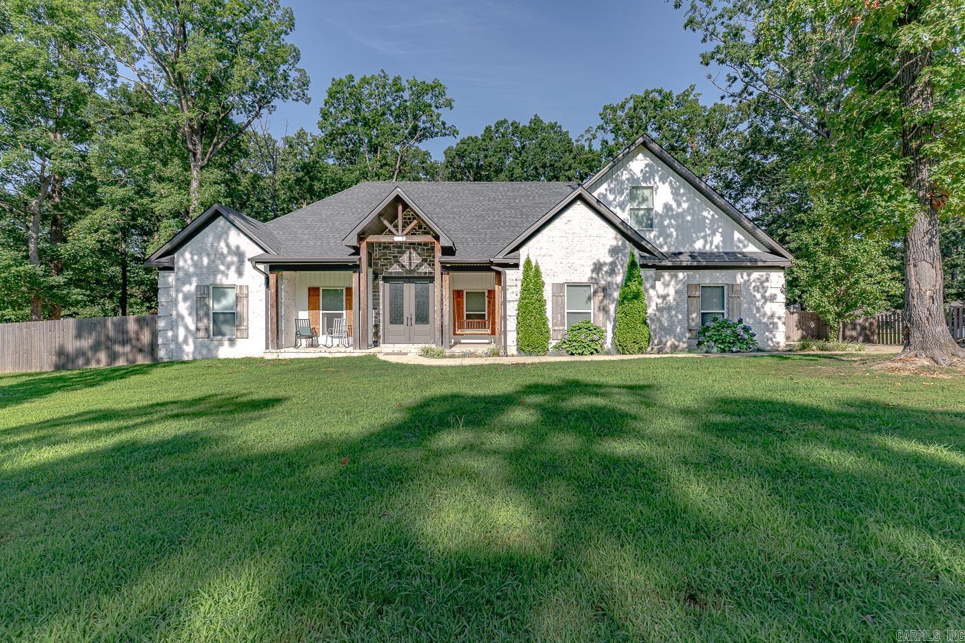 Welcome to Market 551 CR 782 of the Tahoe Village Sub. in Jonesboro, AR within the Brookland School District. Situated on a 1.23 +/- acre privacy fenced lot sprinkled w/ shade trees is a 2021 built Modern Farmhouse. The exterior is wrapped in brick, stone, and vinyl, topped w/ architectural shingles, and accented by shutters, gutters, covered front porch w/ swing & wood posts, covered back patio w/ wood deck, side entry garage, and lavish landscaping. The interior features 2,741 sf of well laid out living space and contains an open concept living/kitchen/dining area. The living room hosts a vaulted ceiling w/ wood beams and electric fireplace. The eat-in kitchen has bar seating, granite countertops, stainless steel appliances, backsplash, walk-in pantry, and access to the patio. The Master wing holds a large bedroom w/ tray ceiling & barn door, and an en-suite w/ garden tub, walk-in tiled shower, dual vanity, walk-in closet, half bath laundry room, mudroom, and kennel. Upstairs is a bedroom w/ closet and floored attic space. The guest wing has 2 bedrooms w/ walk-in closets and full bath. Conveniently located near favorite local amenities. Call today to make this house your home.