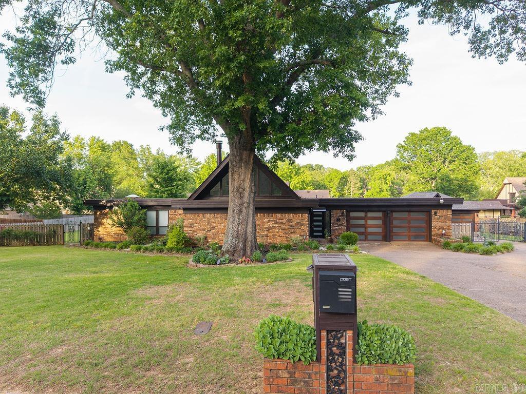 This exceptional, updated home is located in the heart of Fort Smith. Bathed in natural light, the modern residence features three downstairs bedrooms, each equipped with its own full bathroom, in addition to a convenient half bathroom. The spacious living and dining areas create an inviting atmosphere, while the game room, also situated on the ground floor, is ideal for entertaining guests. Upstairs, a versatile bonus room serves as a perfectly quiet reading nook or office space. The home boasts new fixtures and adjustable touch lighting throughout. The updated kitchen is a culinary delight, featuring butcher block countertops, a black granite sink, a mirrored backsplash, and a double oven. A large utility room with a sink adds practicality to the layout. The oversized, fully privacy-fenced backyard offers a tranquil retreat, complete with a fire pit, lush landscaping, and landscape lighting. Additionally, the property includes a two car attached garage and a three car heated, and cooled detached garage, enhancing its appeal.