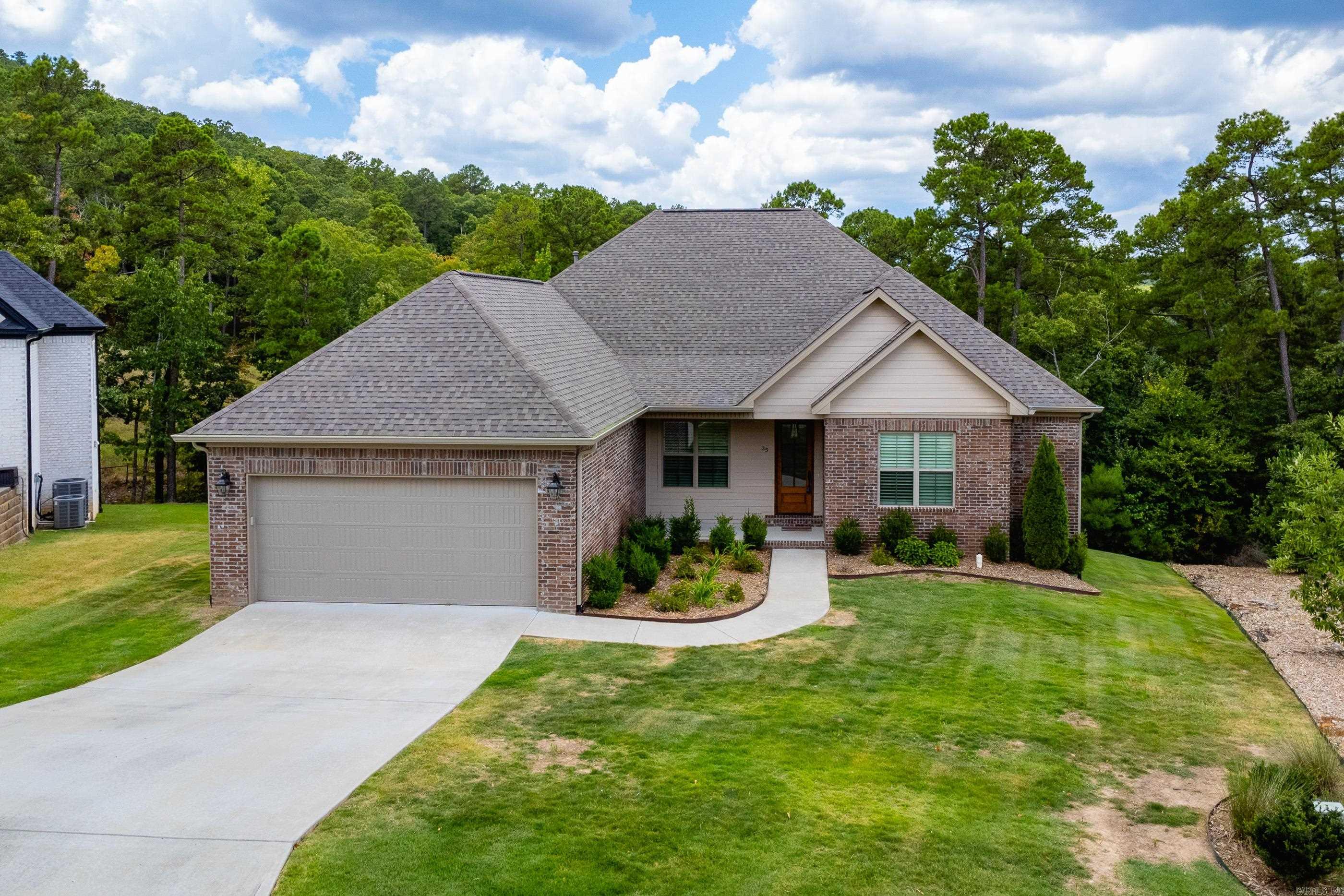 Wonderful like new 2022 brick one level with plantation shutters and a smart, open layout. Beautiful wood floors in living areas, carpet in bedrooms, and tile baths. Vaulted great room with gas fireplace, built-ins, and French doors to a covered deck overlooking green space. Chefās kitchen features a large island with seating, gas cooktop, wall ovens, walk-in pantry, and a dining area that fits a large table within the open space. Spacious primary suite includes a spa style bath and oversized closet. Two guest bedrooms share a bath; a third is set apart near another full bath, ideal for guests or an office. Hallway storage closets, family sized laundry, and drop zone from the two-car garage with walk up attic storage. Under-house storage adds even more space. Come see!