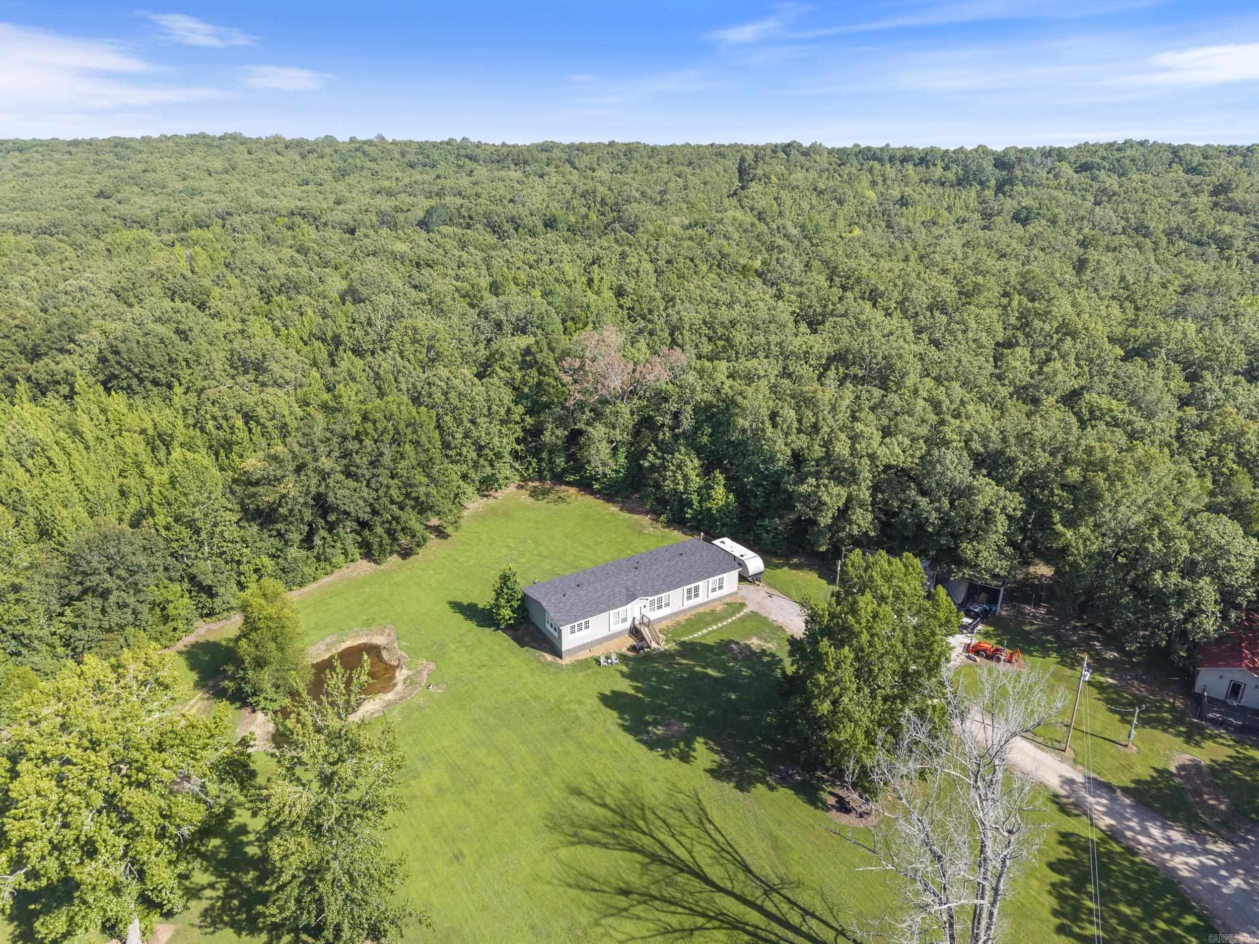 Secluded 19.11-Acre Retreat in Vilonia! Escape to peace and privacy with this spacious 4-bedroom, 3-bathroom home nestled on over 19 acres of beautiful wooded land. This 2,400 sq ft home offers an open, split floor plan with oversized bedrooms, large walk-in closets, and a massive laundry room for added convenience. Enjoy the outdoors with two deer standsāone of which is a fully enclosed standāperfect for hunting or nature watching. Additional features include a separate building for storage and a covered pole barn/parking space that's currently being updated. Whether you're looking for a quiet homestead this property offers the space, privacy, and potential you've been looking for.