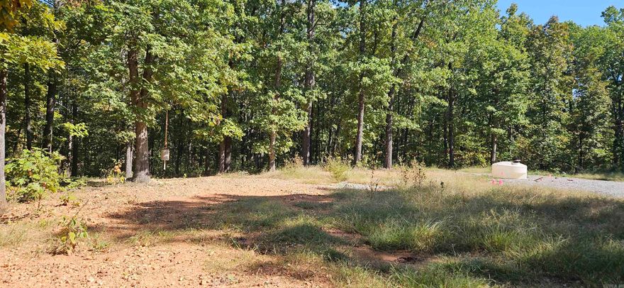 5.03 acres located just 5 miles north of Yellville, off HWY 14. The property boasts mature oak, hickory, and dogwood trees, offering a peaceful, natural setting. Only 5 miles to the Jimmie Creek boat launch on Bull Shoals Lake, and minutes away from Wal-Mart, the White River, and Buffalo River. Included is a 2024 Delta Alliance 30’ travel trailer equipped with an ice maker, an 8x12 tool shop with assorted tools, and a 10x40 steel cargo container. A Honda 400 4-wheeler and a 2-person Zodiac raft with a 3.5 HP Mercury motor are also included. The property features a well with pumphouse, water softener, and two frost-free hydrants, along with electricity (110/30/50 amp service) and a security light. A gravel driveway with parking, a fire pit, and more complete the package. Trailer is hooked up to a 3+ bedroom septic. A must-see!