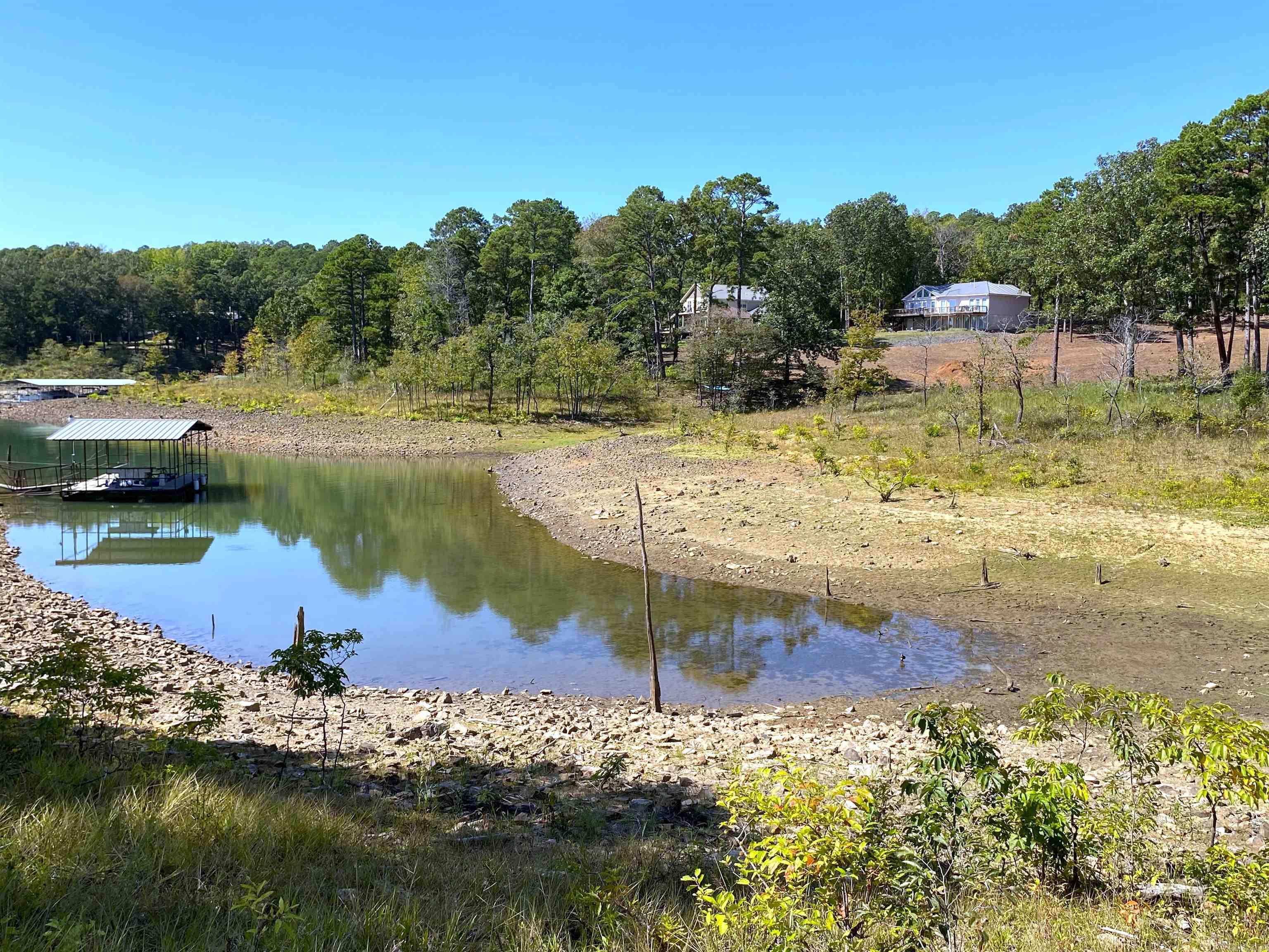 7 wooded acres nestled along the picturesque shores of Greers Ferry Lake. This remarkable property features an exceptional white line and is situated in a coveted boat dock zone, this parcel, subject to approval from the Corps of Engineers, presents a unique chance to build your dream lakeside retreat. Set within a well-established neighborhood, this property epitomizes serenity and seclusion. Imagine waking up to the soothing sounds of nature and enjoying the privacy that comes with the surrounding woods. Whether you envision a cozy cabin or an expansive estate, the possibilities are endless. With water, electricity, and high-speed internet readily available, you can seamlessly blend modern convenience with the tranquility of lakeside living. There is also a boat launch ramp only 1000 feet away from the property. Call a agent today for details and don't let this one slip past you!