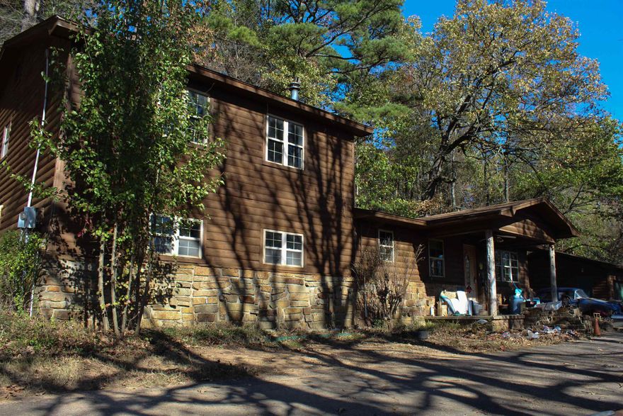 Don't miss this rare opportunity to own a piece of local history! This 4-bedroom, 2-story home sits on 2.5 acres and is just minutes away from the Lake of Dardanelle State Park. While the home needs repairs, it offers tons of potential. The floor plan features 2 bedrooms upstairs and 2 downstairs, with a spacious living room, bonus room, kitchen, and laundry room. What makes this property truly unique? Seller says former Razorback golfer John Daly lived here! The property also includes 2 full bathrooms and a detached 3-car garage for extra storage or conversion to additional living space. If you're an investor, a Razorback fan, or want to renovate to make it your own, this is for YOU! Property sold AS-IS.