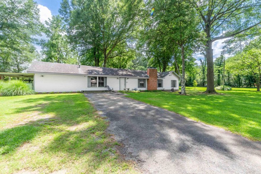 This spacious 3-bedroom, 2-bath home offers plenty of room to live and relax, all set on over five acres backed by mature woods. Enjoy the natural surroundings while staying close to town conveniences.  Inside, this move-in ready and well-maintained home provides ample living space for everyday comfort and entertaining. A versatile bonus room adds to the living areas and can be used as an office, playroom, or extra space to fit your lifestyle. The primary bedroom includes a generously sized closet, a bath with an oversized whirlpool tub and separate walk-in shower, and direct outdoor access. The kitchen refrigerator and gas clothes dryer stay with the home, making your move easier. Additional features include two water heaters, solar-powered attic vents, and a whole-house generator that automatically powers on during outages, ensuring comfort and reliability year-round.  Outside, you’ll find a large paved patio surrounded by mature trees and a lush, gorgeous St. Augustine lawn. The property also includes a small easement along the future Southwest Bike Trail, offering a unique community amenity nearby.  Schedule your showing and see if you’re ready to make this house your home!