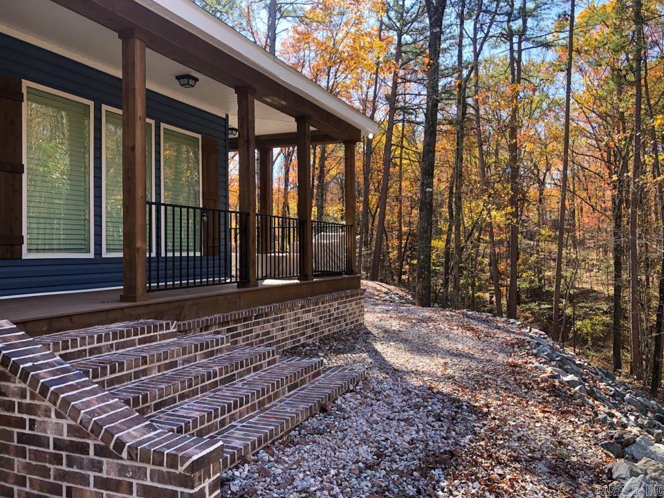Discover a brand new modular home located just 1 mile from the stunning, crystal-clear Lake Ouachita. Set on a spacious 3.89-acre lot adorned with plenty of trees, a creek, this property is a true gem. Ample parking is available for everyone, including boats and recreational vehicles, all with no restrictions or monthly fees. The home boasts an open floor plan and a modern, updated kitchen featuring abundant storage, quartz countertops, and a farmhouse-style stainless steel sink and appliances. Luxury vinyl flooring flows throughout the space. The master bedroom is generously sized, offering beautiful views of the surrounding trees through windows that let in plenty of natural light. The master bath includes double vanities, a large soaking tub, and a tiled walk-in shower complete with a rain showerhead, alongside two separate walk-in closets. The second and third bedrooms are also spacious and equipped with walk-in closets. Additional features include a convenient switch at the hot water heater for easily disconnecting if youāre away for an extended period, ample storage in the laundry area, and access to a wrap-around deck from two areas.